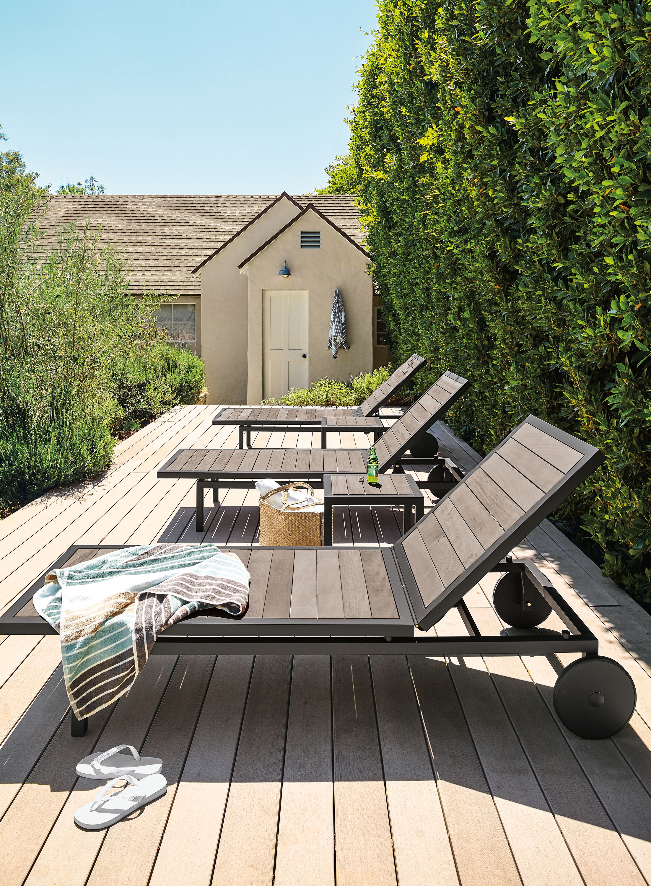 Wooden sun deck with 3 Montego chaises in graphite and aged thermally modified oak.