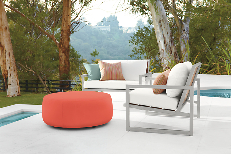 Outdoor pool setting with two Montego Lounge Chairs with Cushions and a Boyd 36-round Outdoor Ottoman.