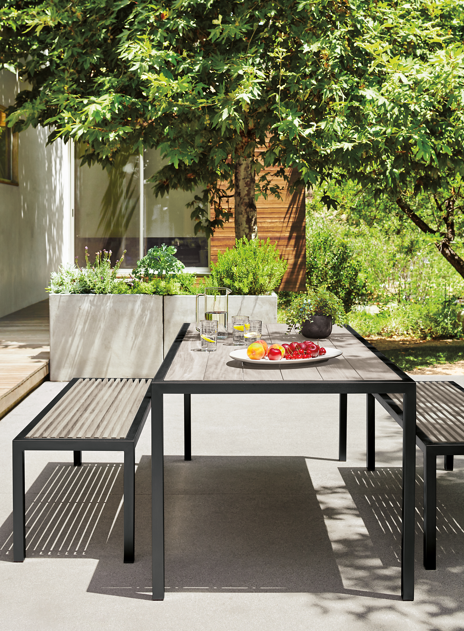 patio with montego table in aged ash and six bellini chairs in black.