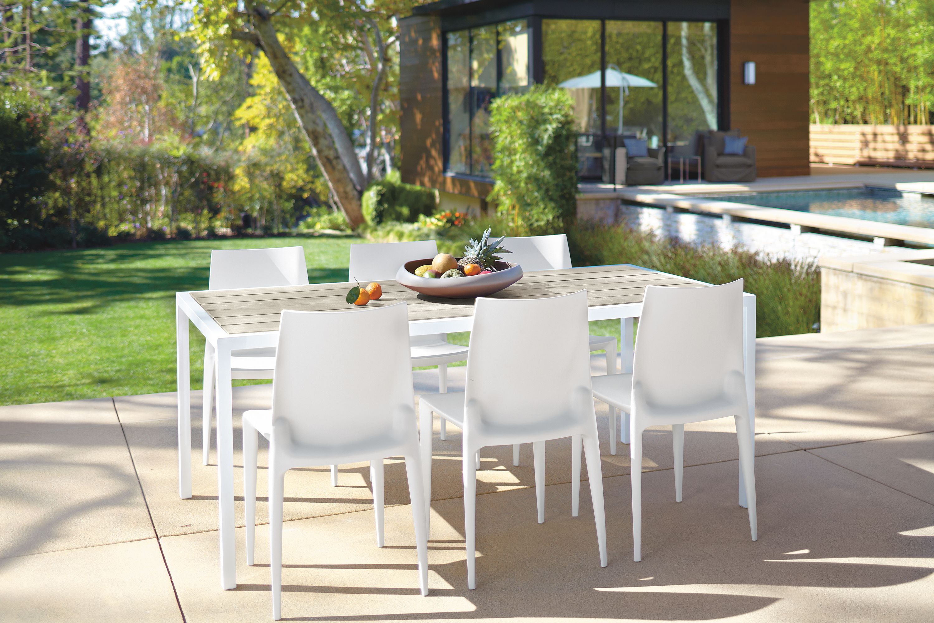 outdoor dining space with montego table and bench in aged ash, 5 sabrina chairs.