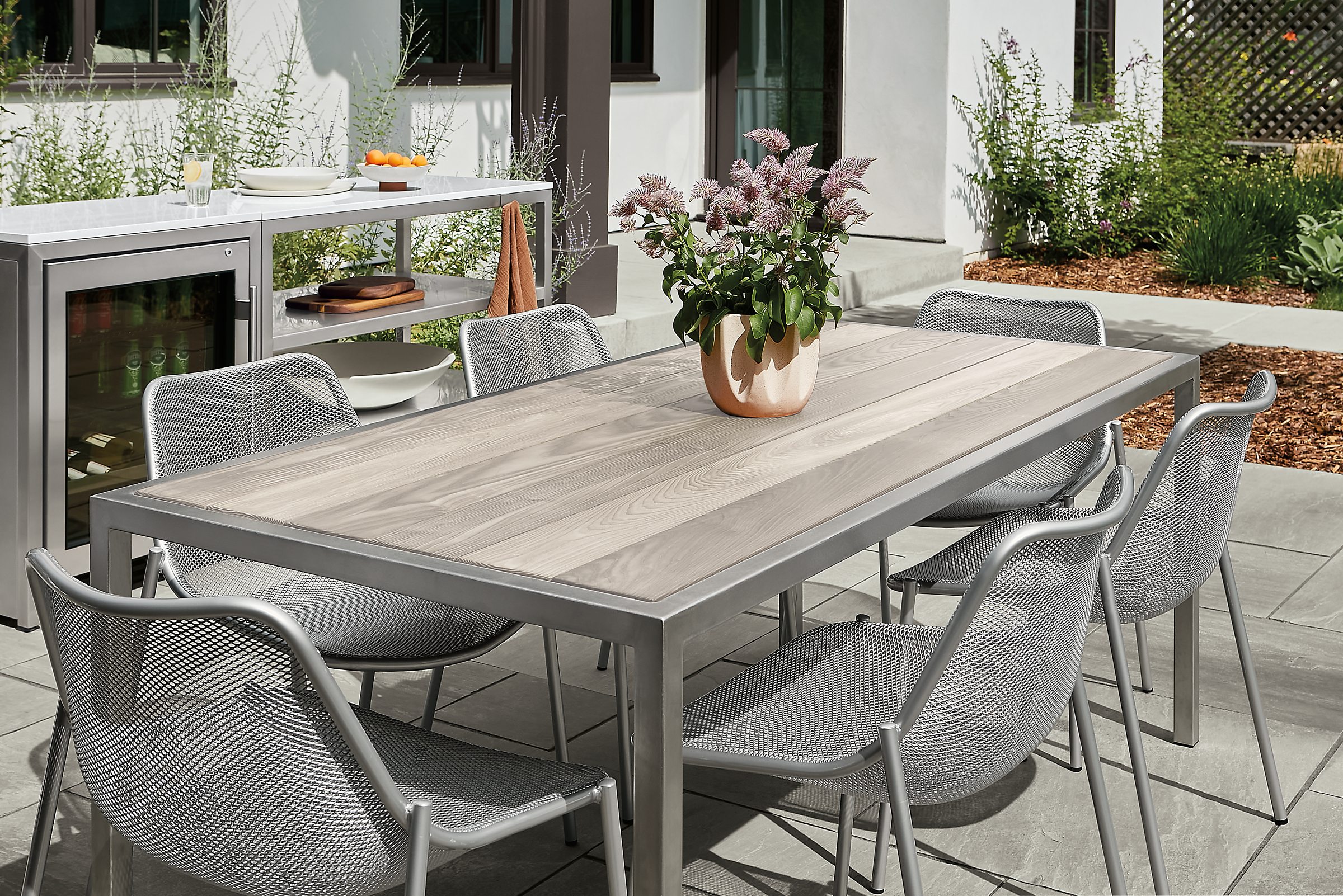 Outdoor space with montego dining table in aged thermally modified ash and six soleil side chairs.