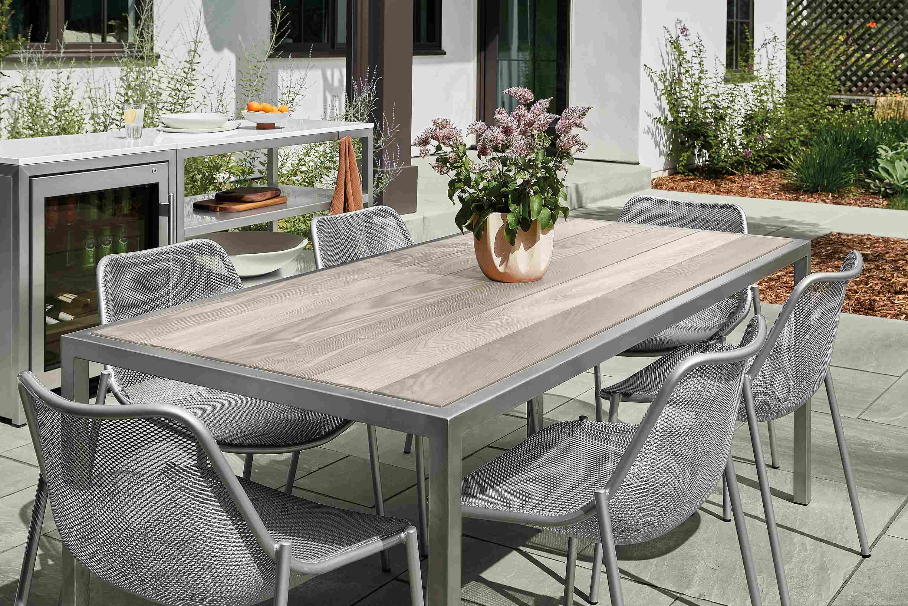 Outdoor space with montego dining table in aged thermally modified ash and six soleil side chairs.