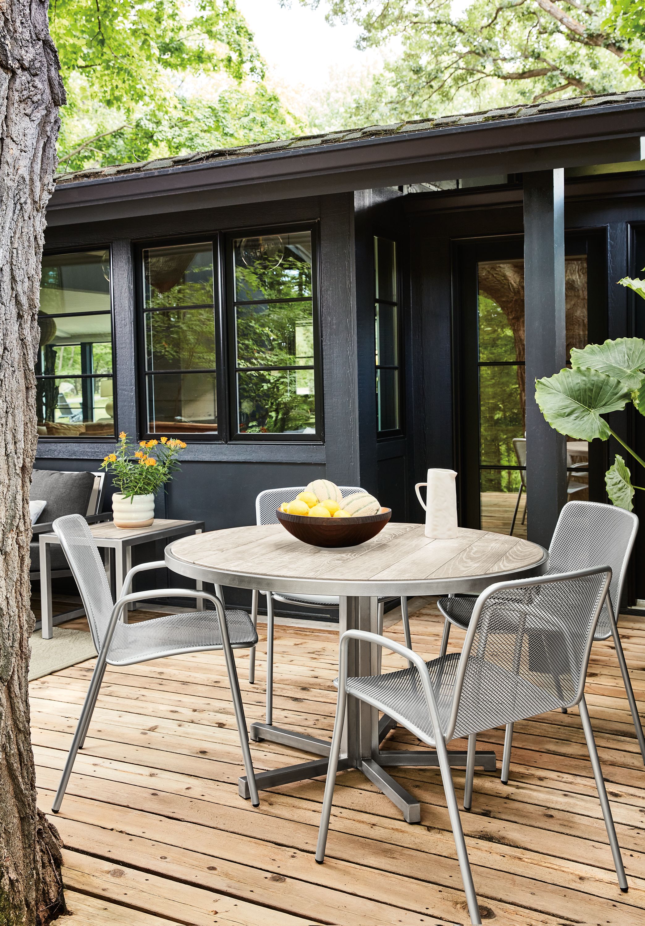 Montego 48-round outdoor dining table in stainless steel with aged Thermally modified ash wood with Aruba chairs in silver.