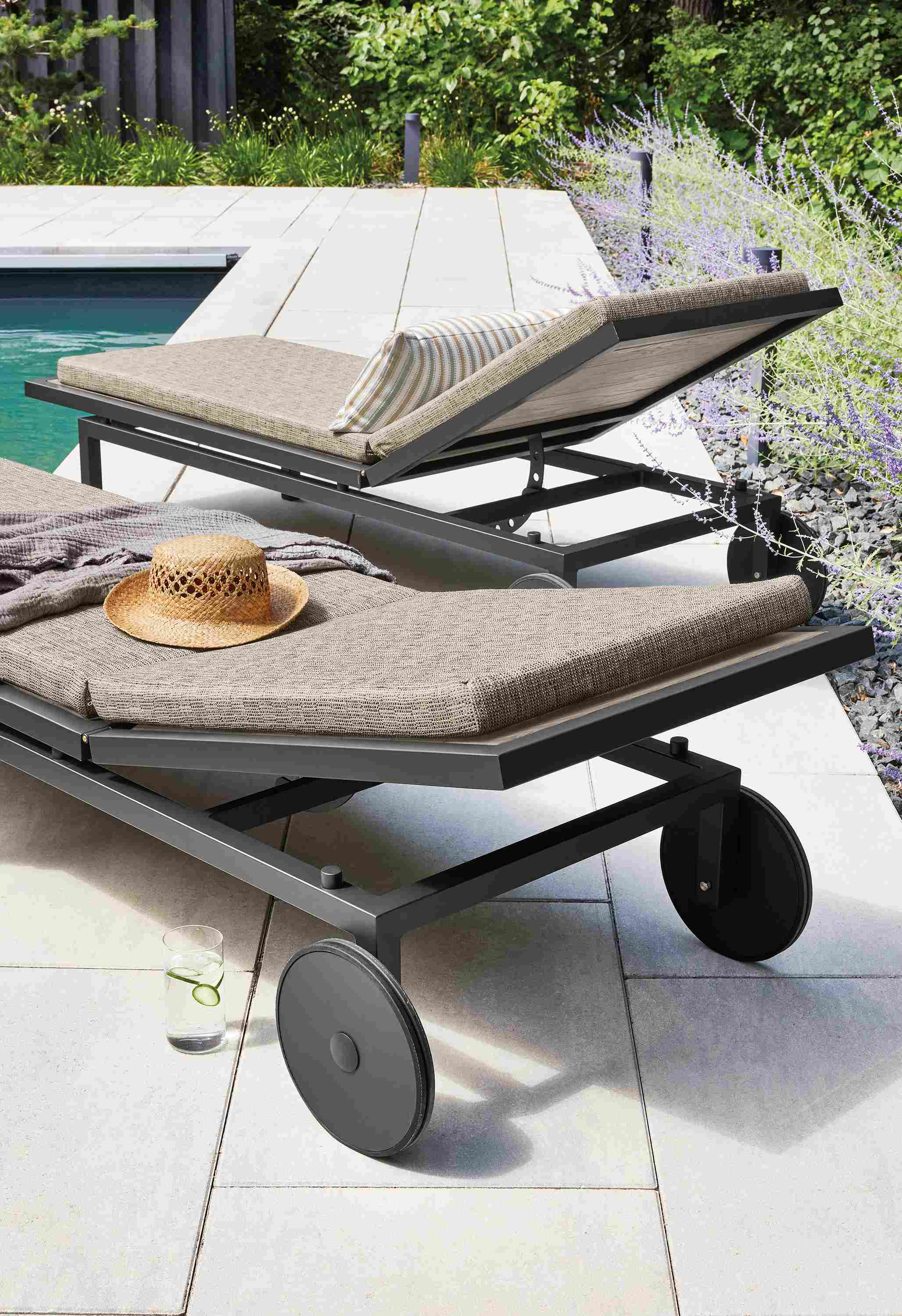 Outdoor space with two Montego chaises in aged thermally modified oak with cushions in Mist Oatmeal fabric.