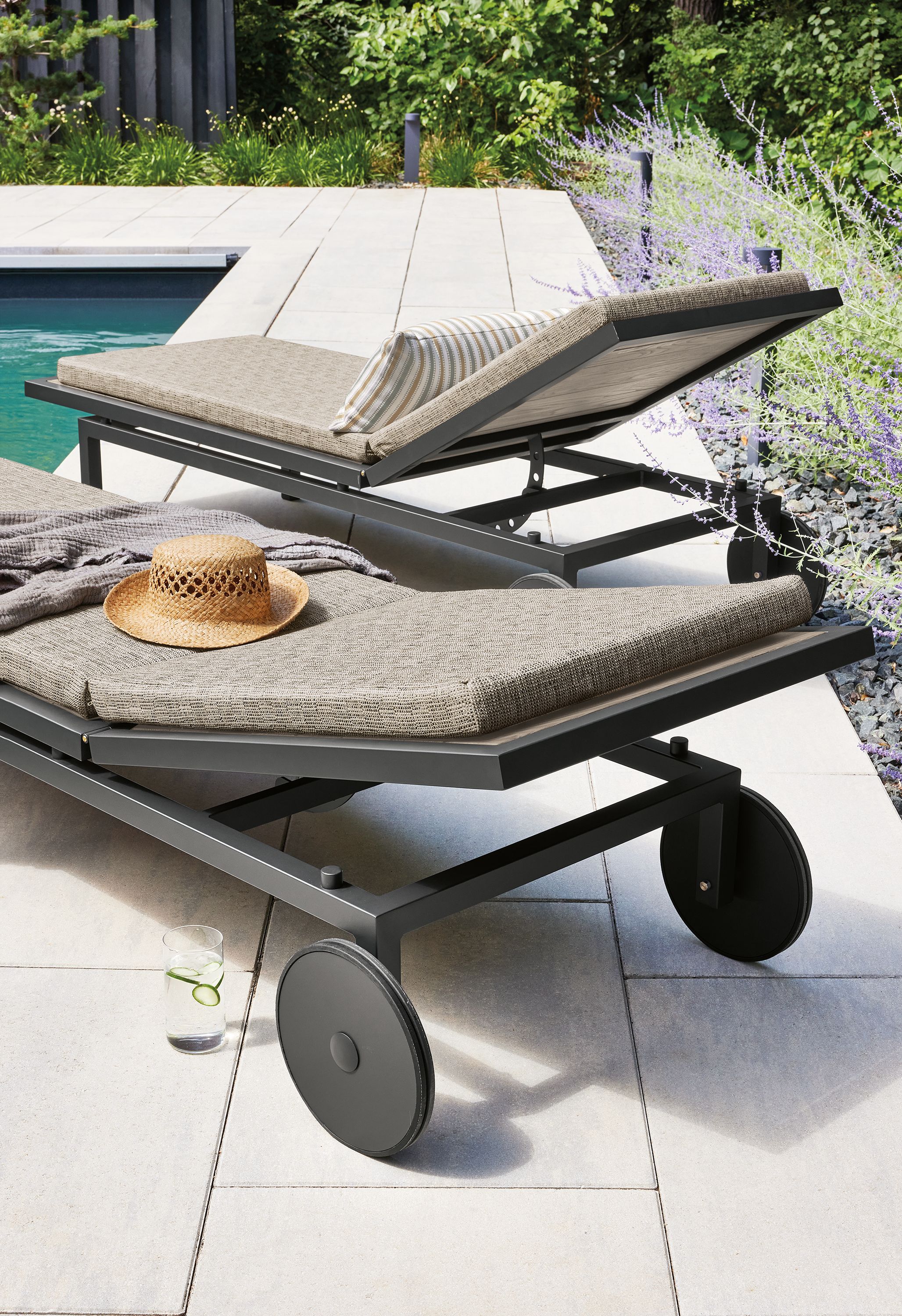 Outdoor space with two Montego chaises in aged thermally modified oak with cushions in Mist Oatmeal fabric.