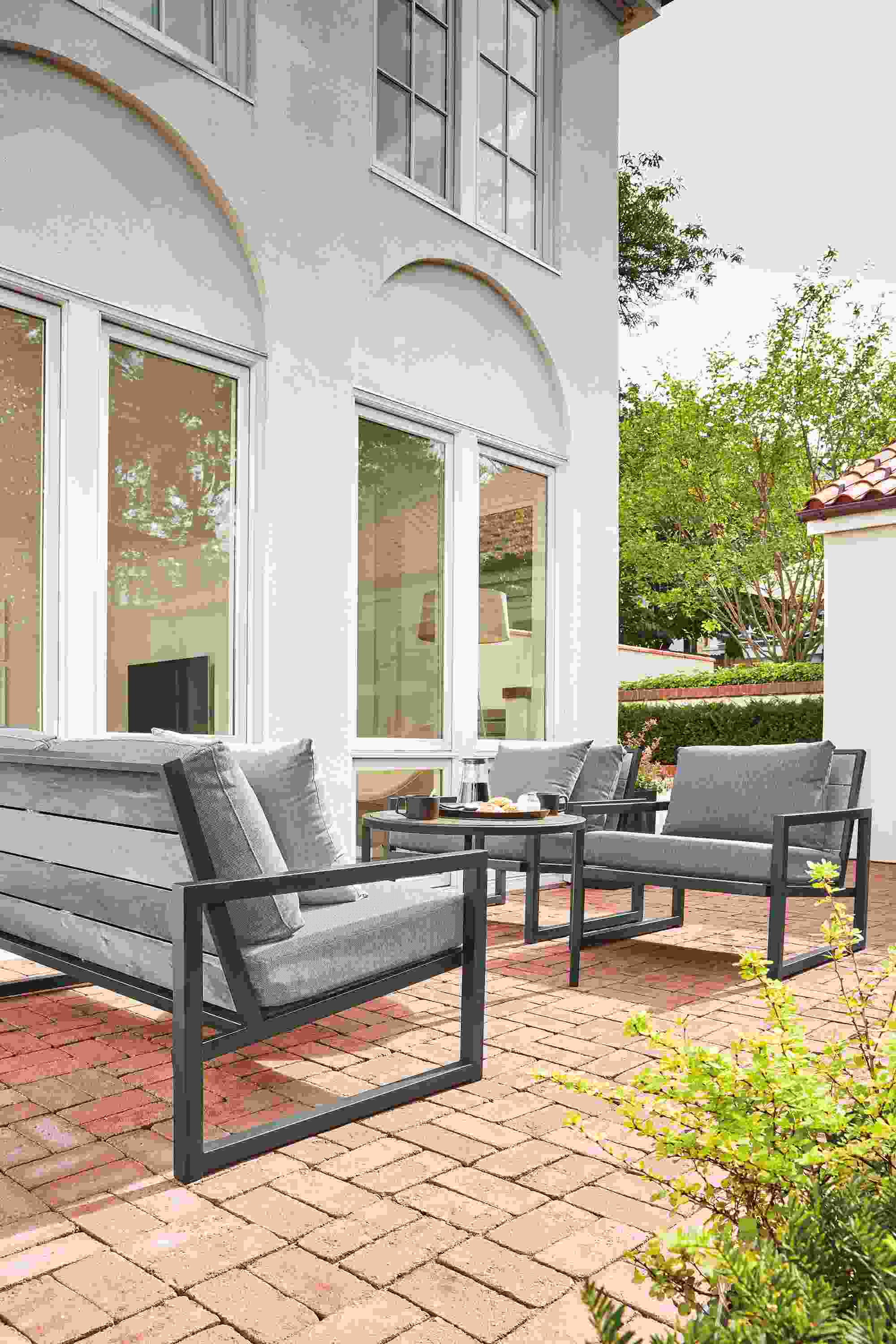 Brick patio with Montego 64-wide bench in thermally modified ash with graphite base and Mist Navy cushions.