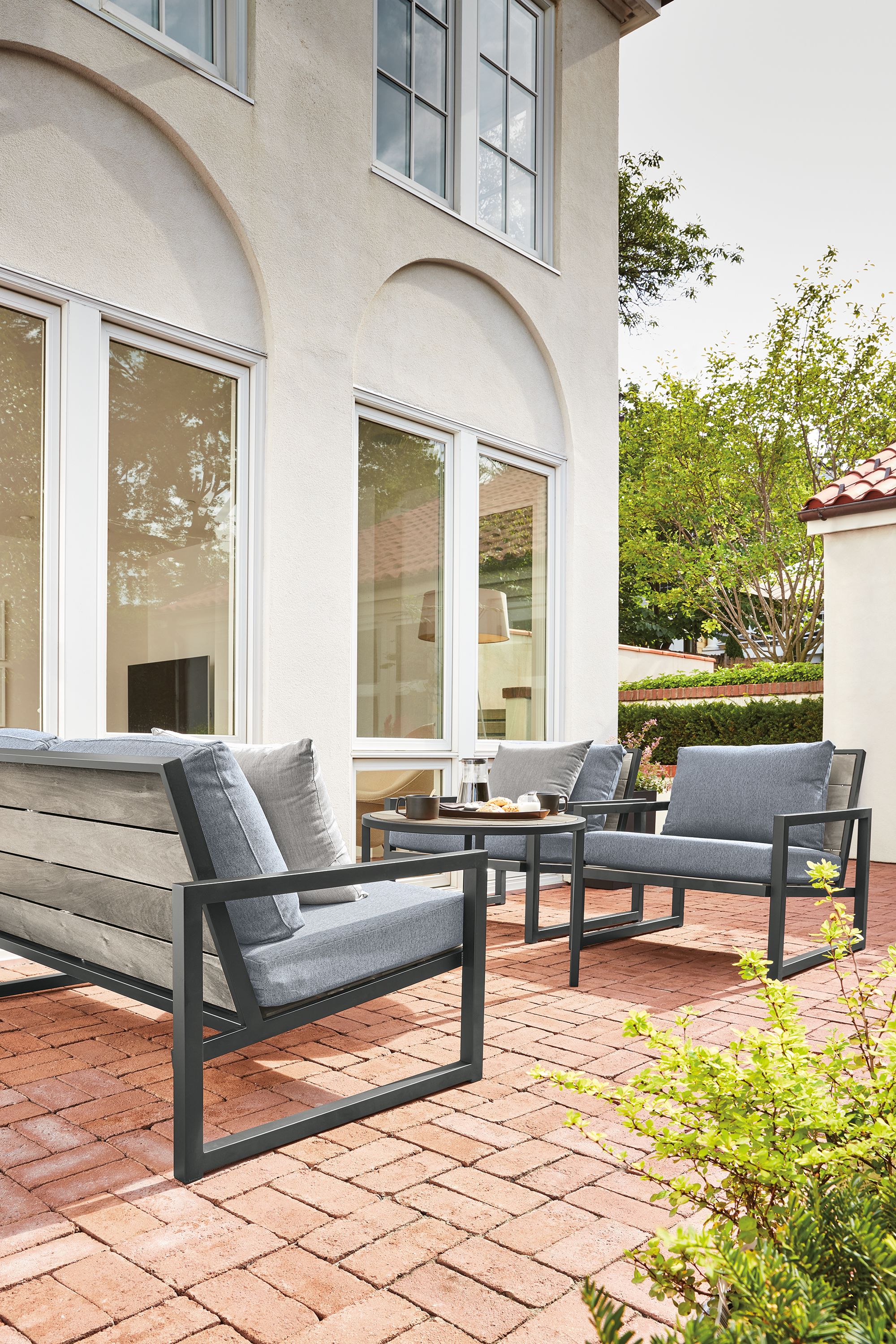 brick house porch with montego 64-wide bench in aged ash with graphite base.