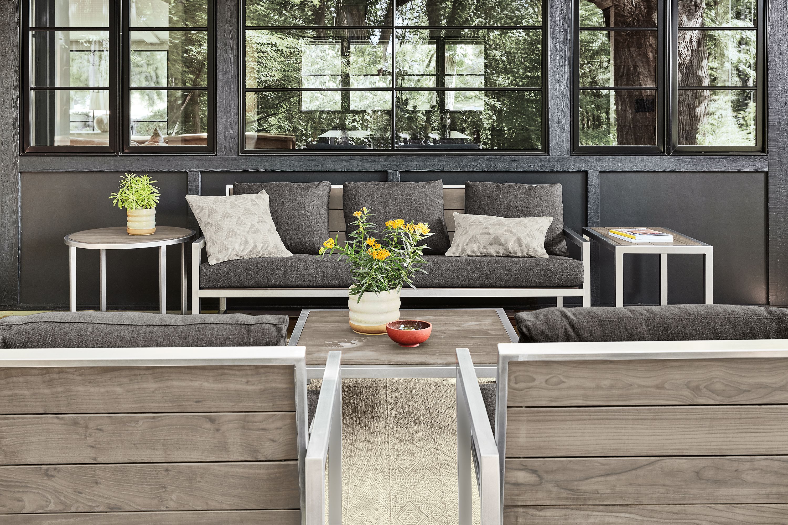 Montego sofa with Mist charcoal cushions, coffee table and two end tables in stainless steel with aged Thermally modified ash wood.