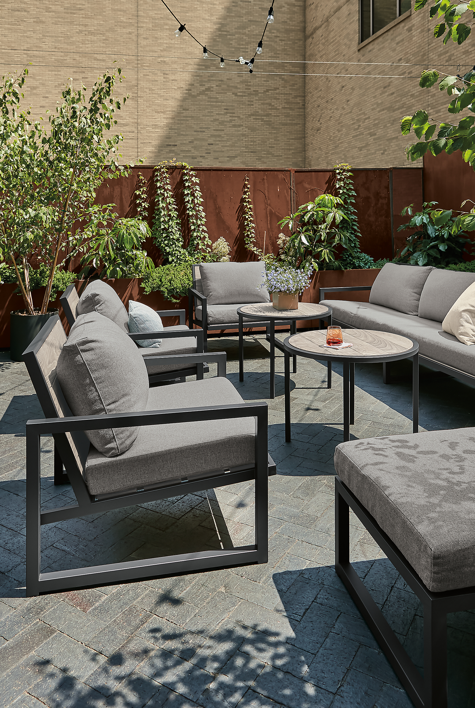 Outdoor space with aged thermally modified ash montego chairs with cushions in mist fabric.
