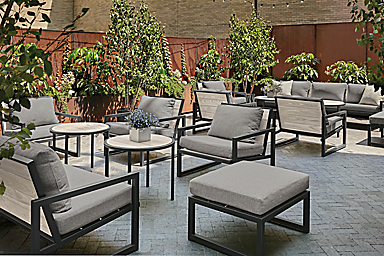 Outdoor lounge space with aged thermally modified ash montego chairs with cushions and montego round side tables.