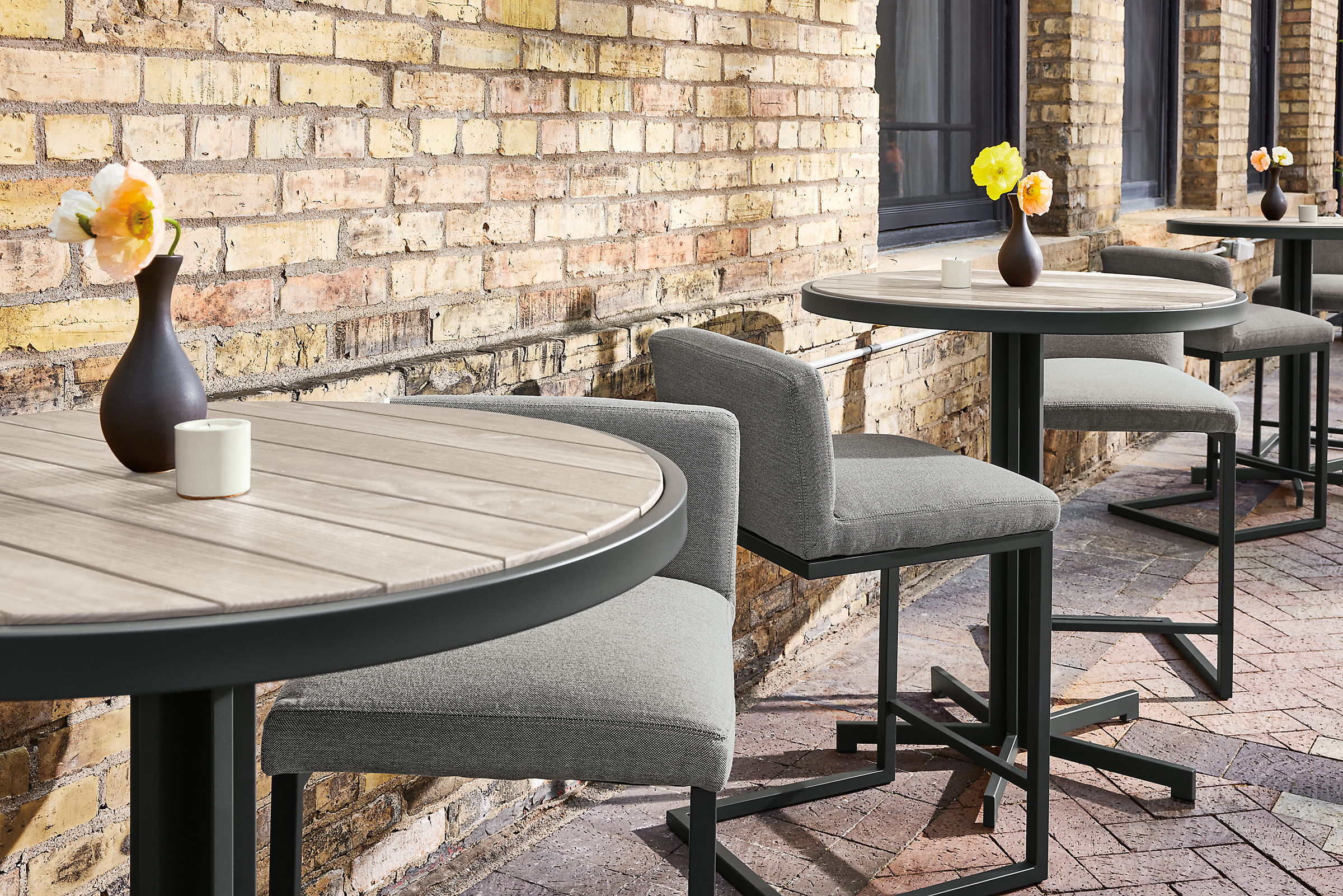 detail of Outdoor dining space with aged thermally modified ash montego round counter tables and finn counter stools.