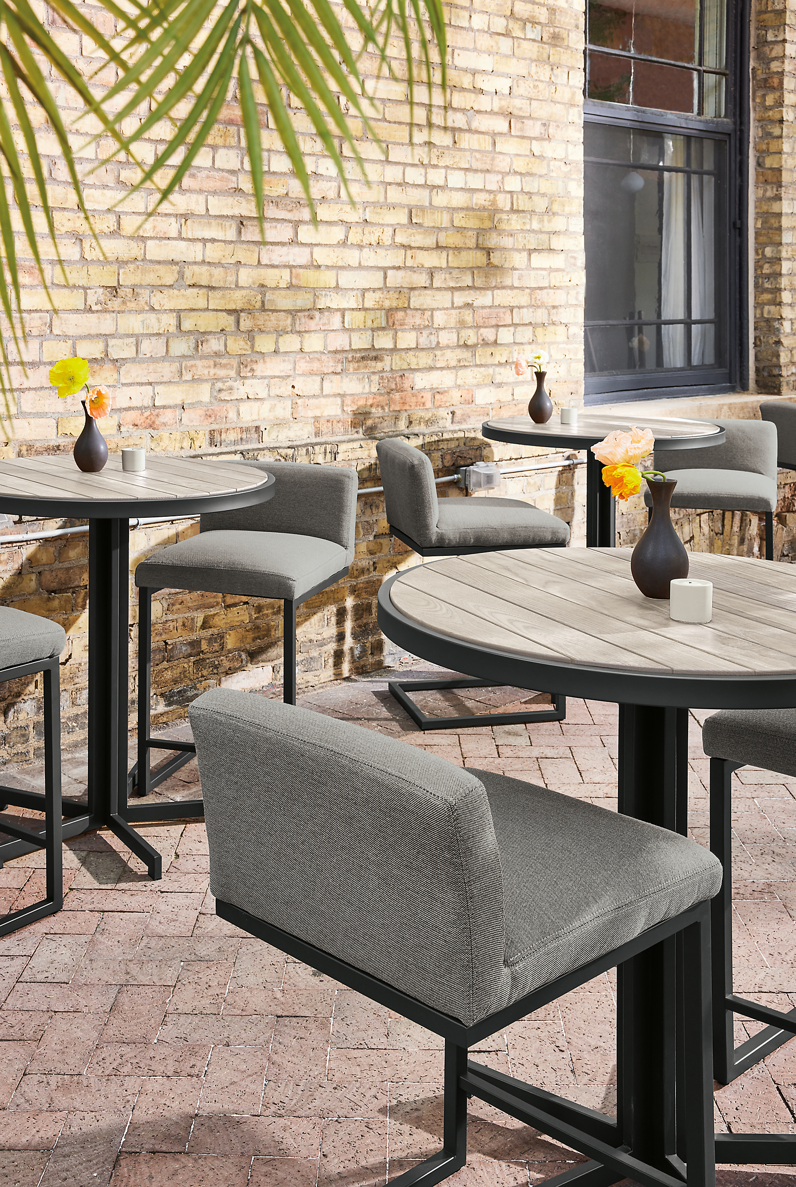 Outdoor dining space with montego round counter tables in aged thermally modified ashand finn counter stools.