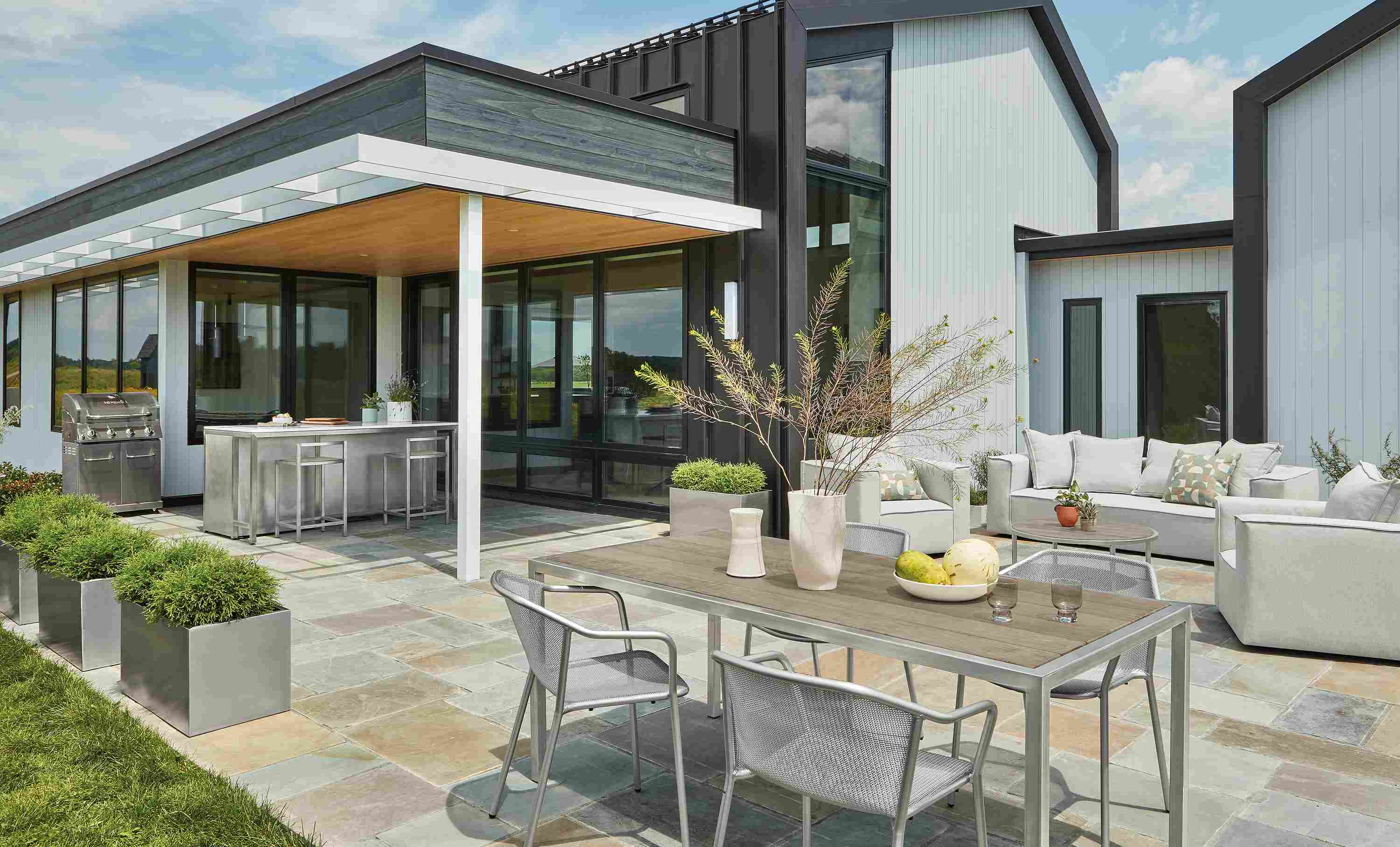 Patio with montego table in stainless with aged thermally modified oak and 4 theo chairs in silver.