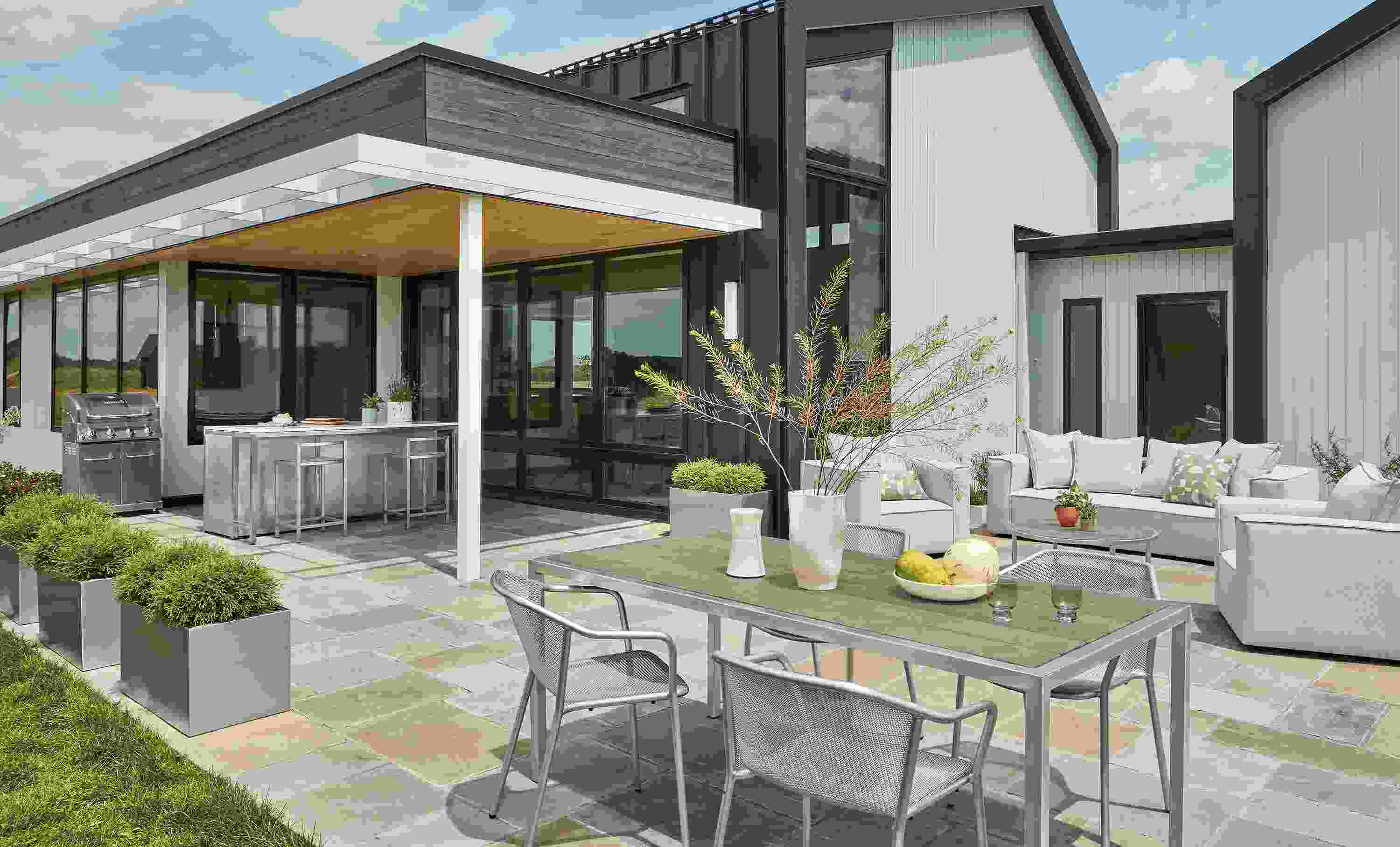 Patio with montego table in stainless with aged thermally modified oak and 4 theo chairs in silver.