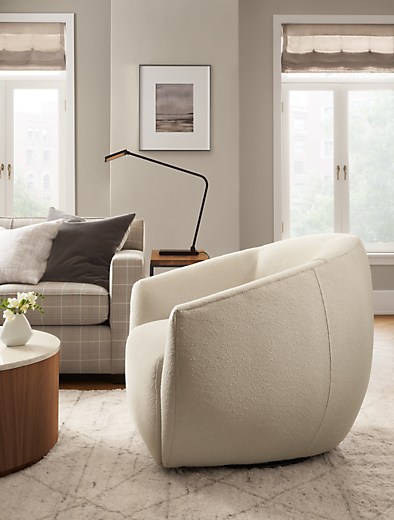 Room setting with Mora swivel chair and Dean sofa, with a Liam 36-round Coffee Table in Walnut.