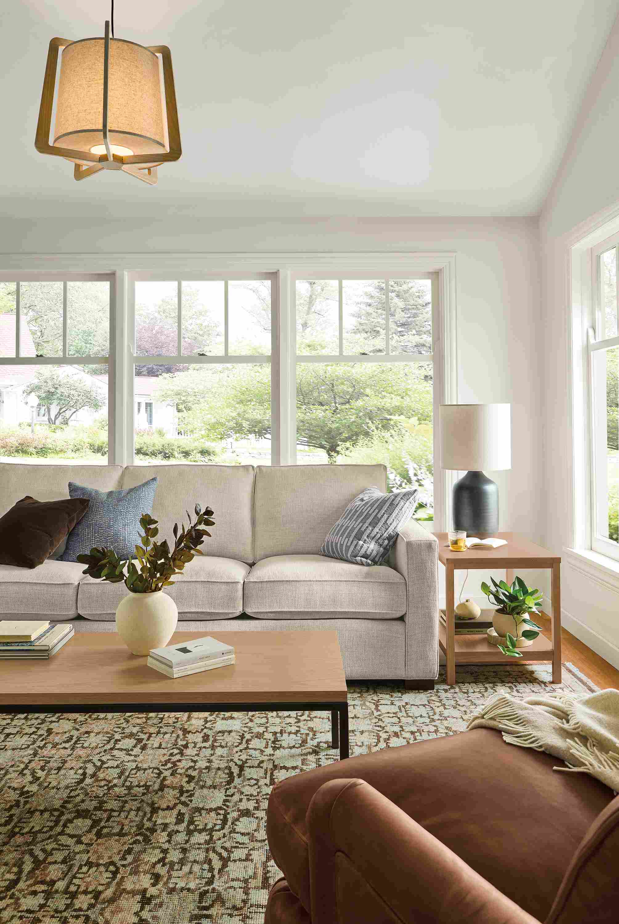 Living room with Morrison sofa in Olmstead Natural, Humphrey chair in sarto cognac leather and Rosalie rug in petal.