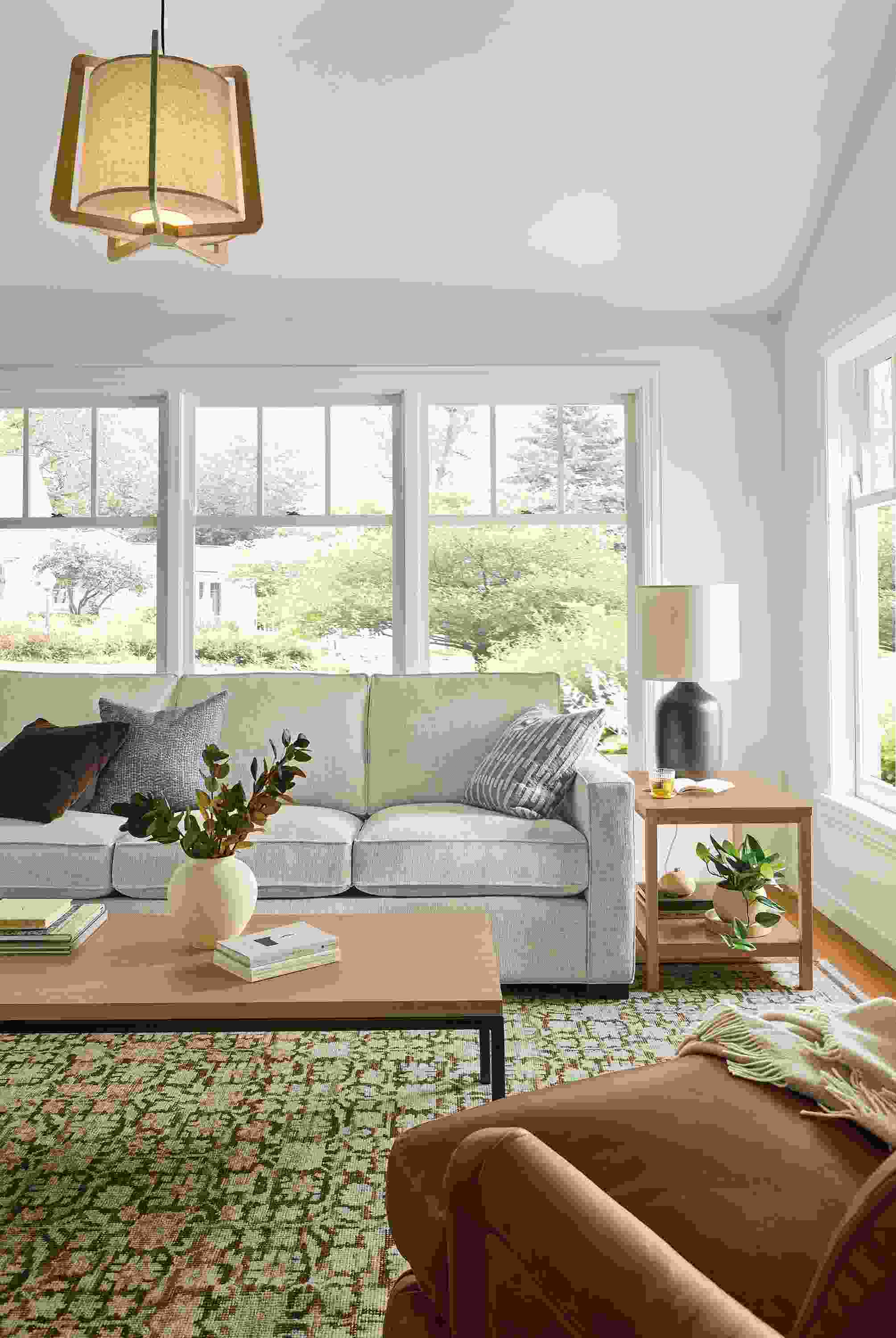 Living room with Morrison sofa in Olmstead Natural, Humphrey chair in sarto cognac leather and Rosalie rug in petal.