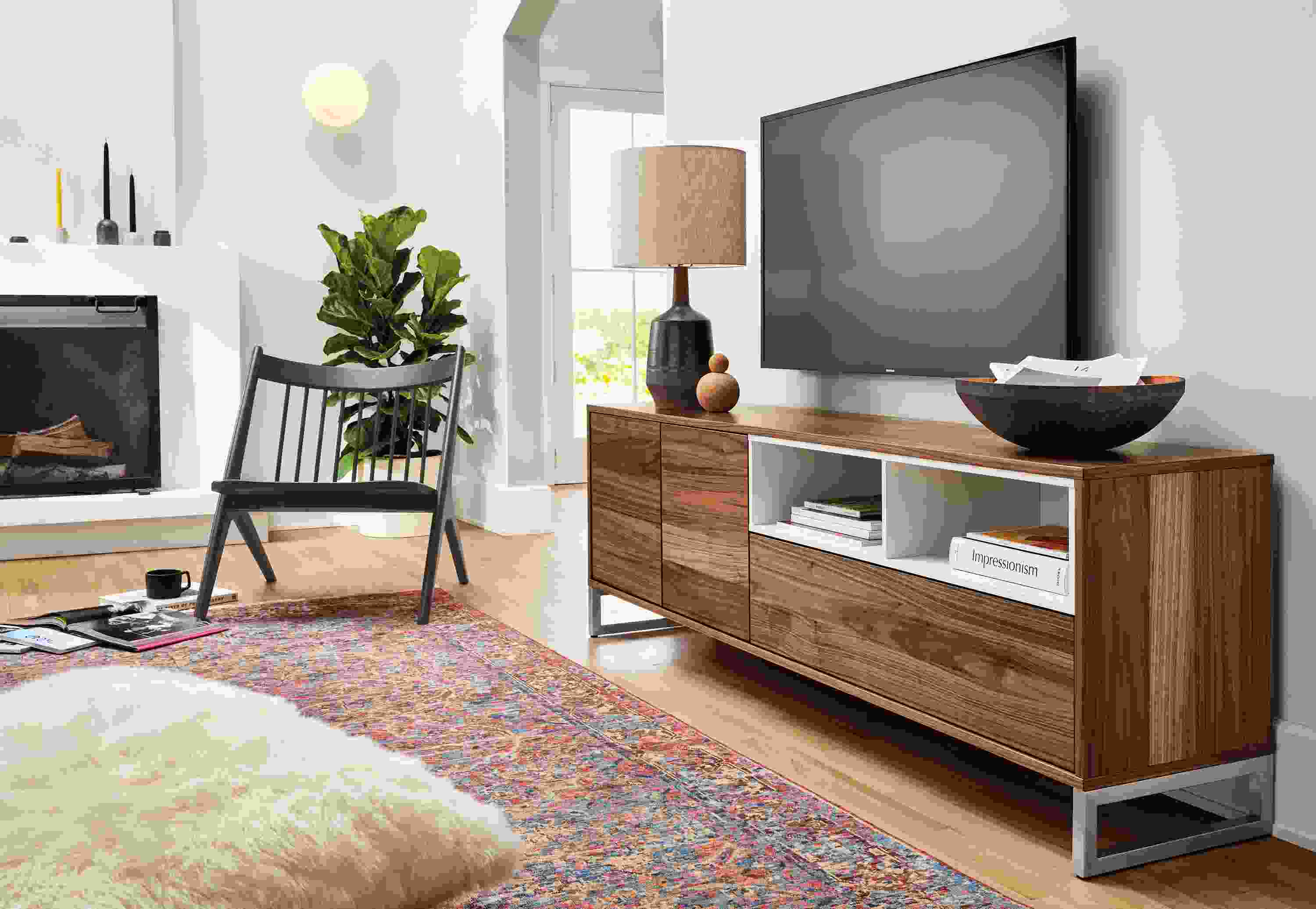 Living room setting with a Mosby storage cabinet and an Oskar Armless Lounge Chair in Charcoal on a Cassia Rug in Pink.