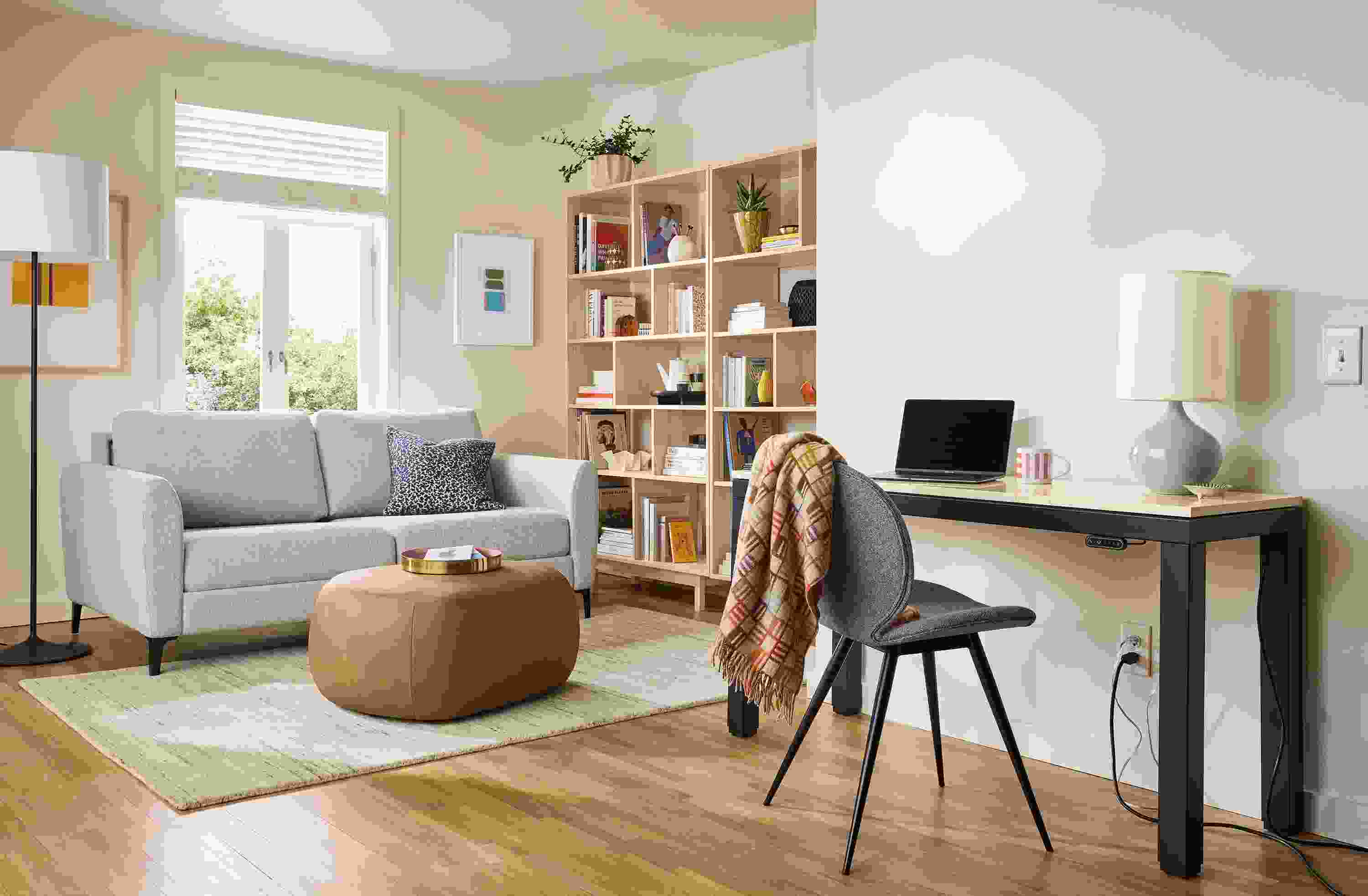 Apartment room with Natalia 72-wide queen sleeper sofa in Conley Natural, Asher ottoman in Laino Camel leather.