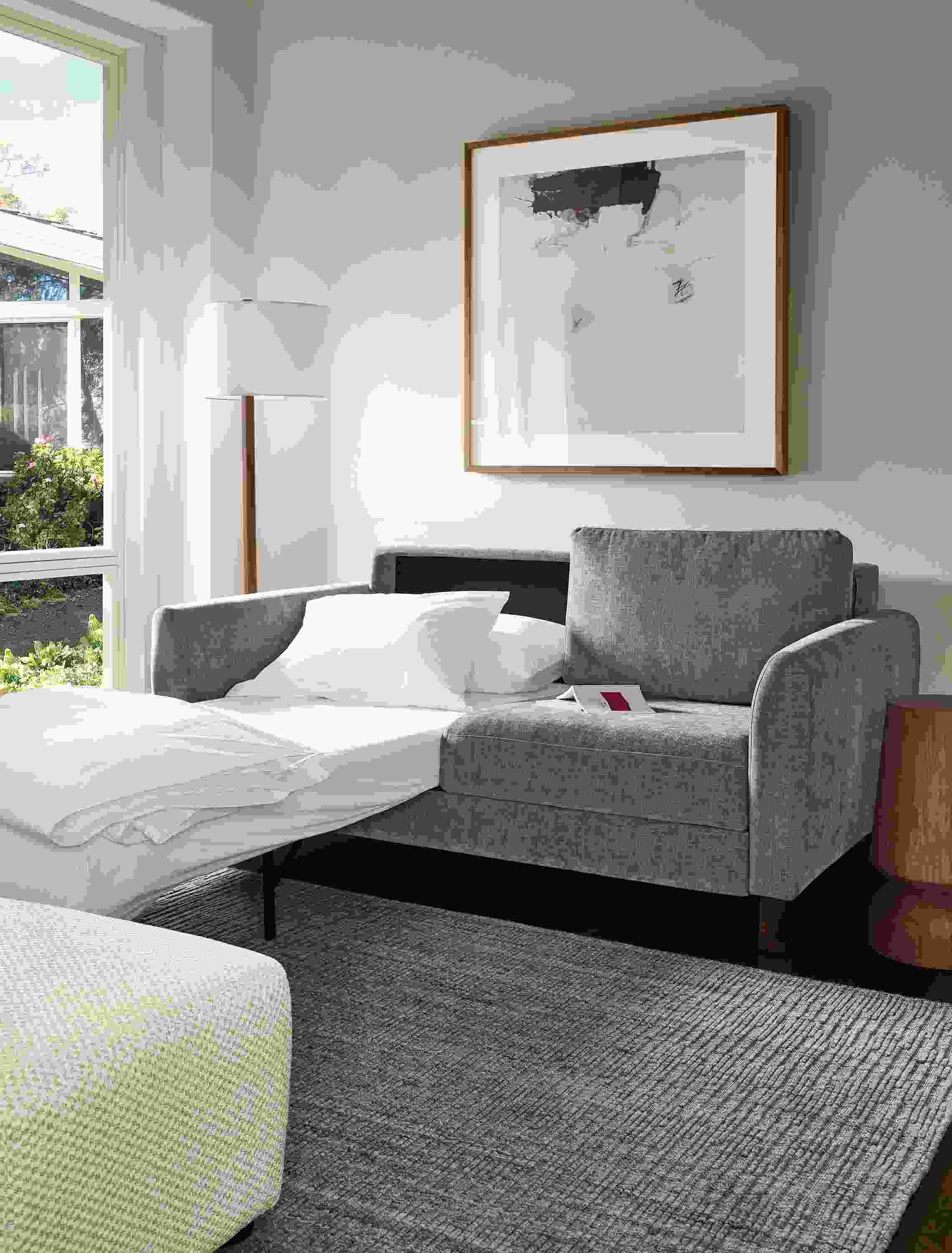 Living room with Natalia 72-wide queen sleeper sofa in Mori Graphite shown with one bed side open and extended.