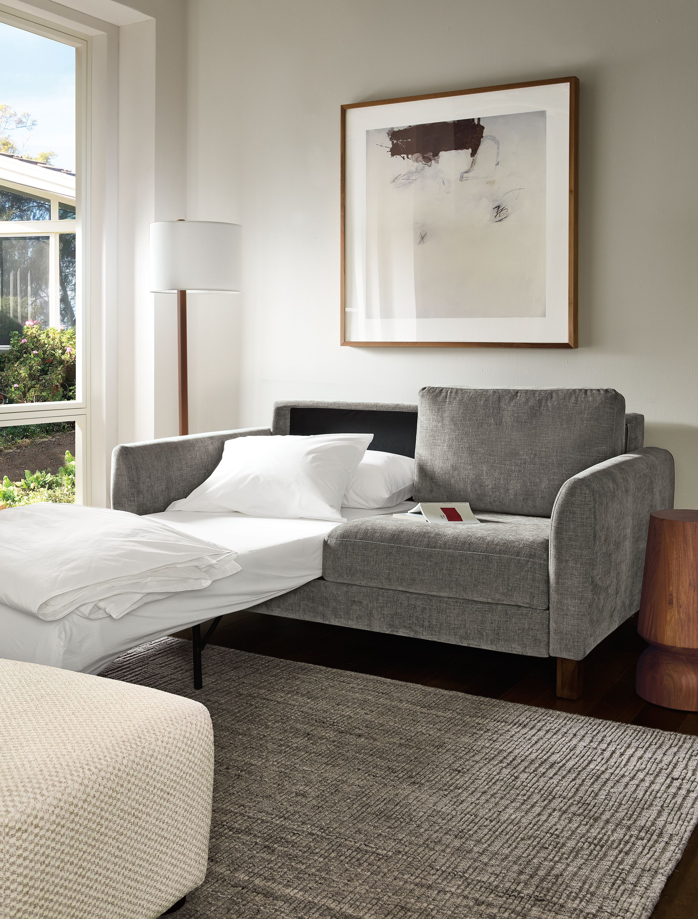 Living room with Natalia 72-wide queen sleeper sofa in Mori Graphite shown with one bed side open and extended.