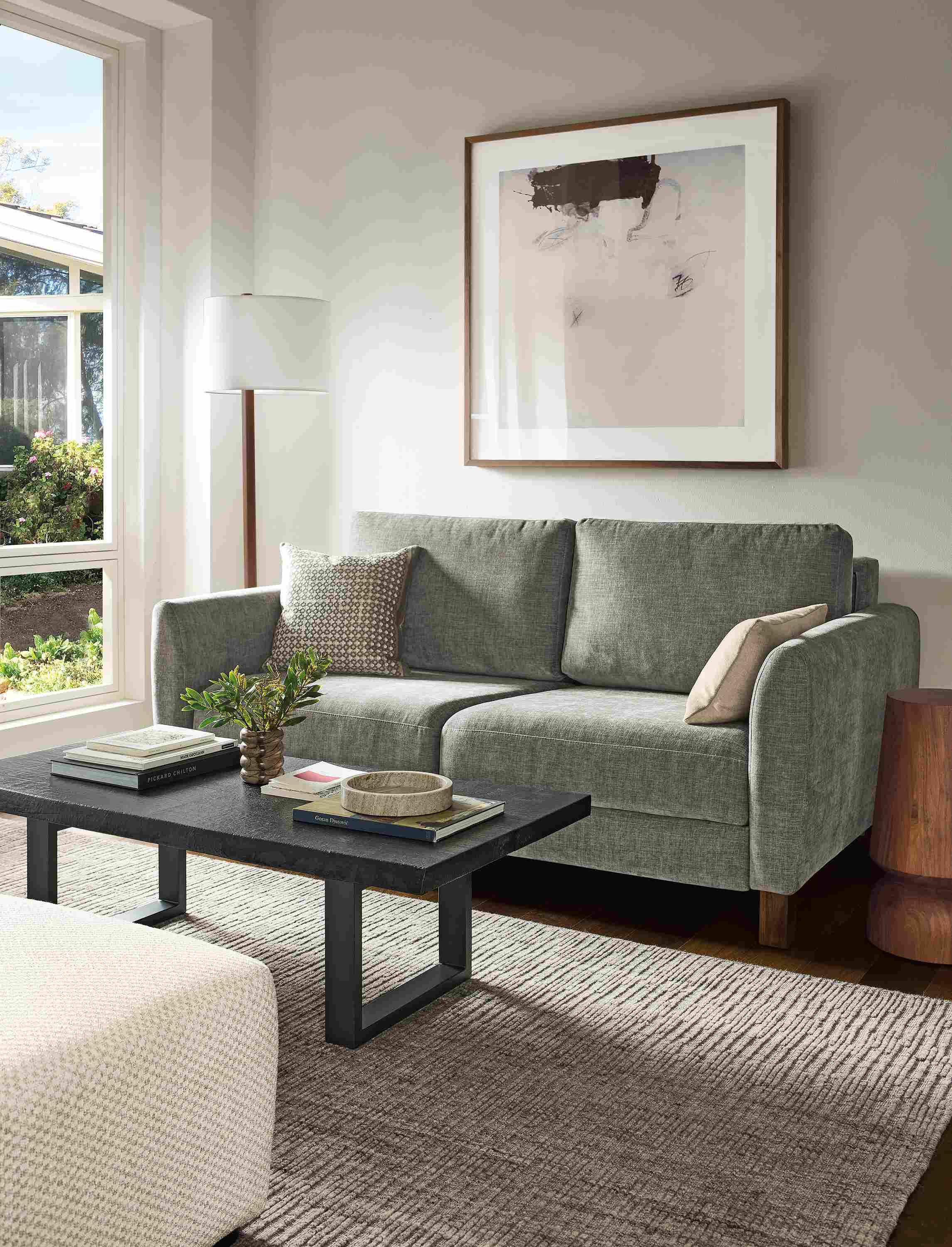Living room with Natalia 72-wide queen sleeper sofa in Mori Graphite and Artis 6 by 9 rug in grey.