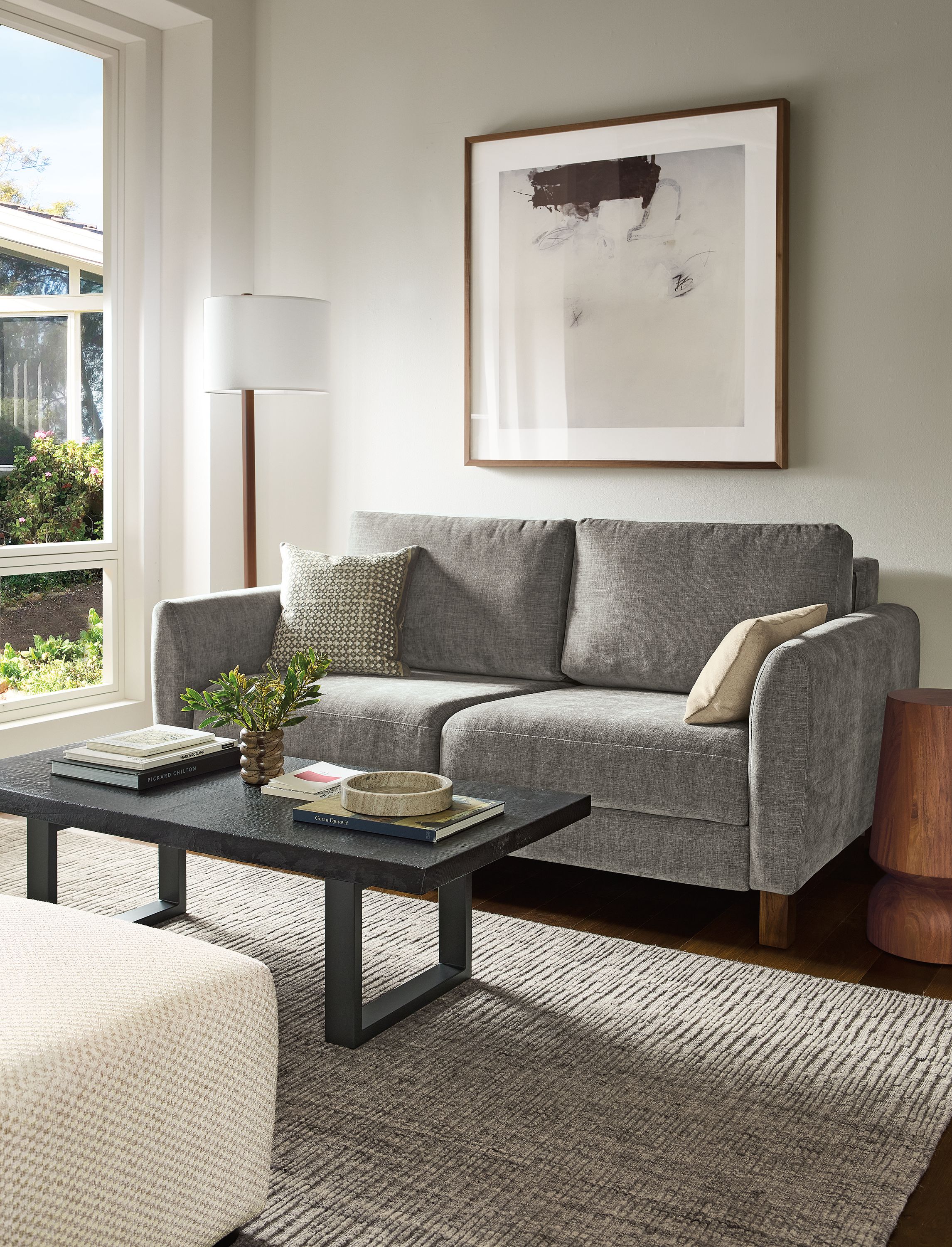 Living room with Natalia 72-wide queen sleeper sofa in Mori Graphite and Artis 6 by 9 rug in grey.
