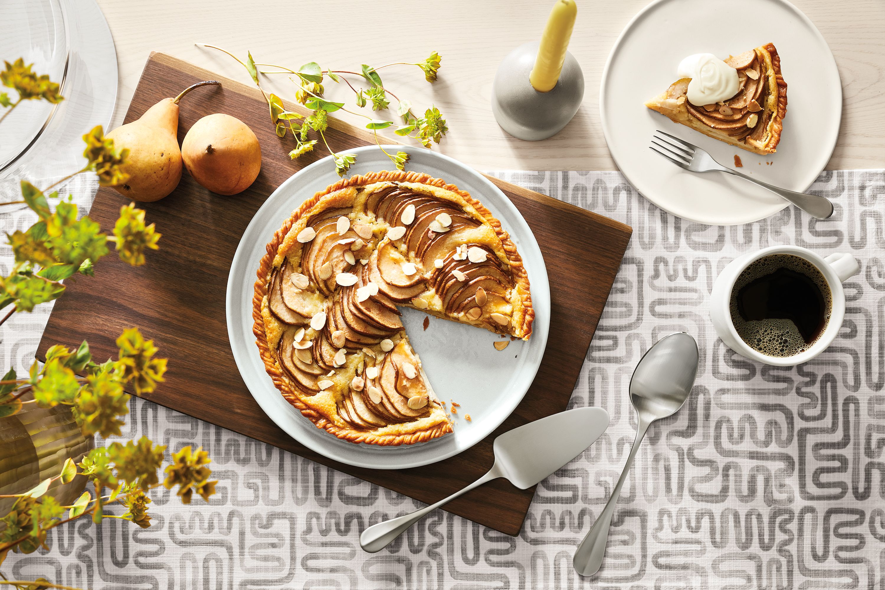 detail of notos dinner plate with pear pie on it on dining table.