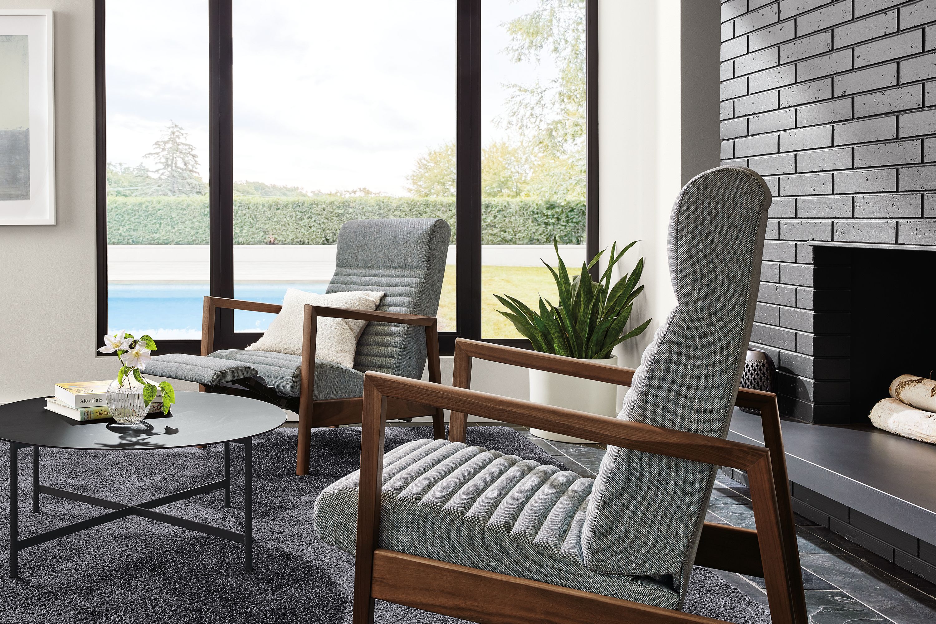 Living area with Nilsen Recliners in Sumner steel fabric and walnut, Circuit 36-round coffee table in graphite and Arden rug in coal.