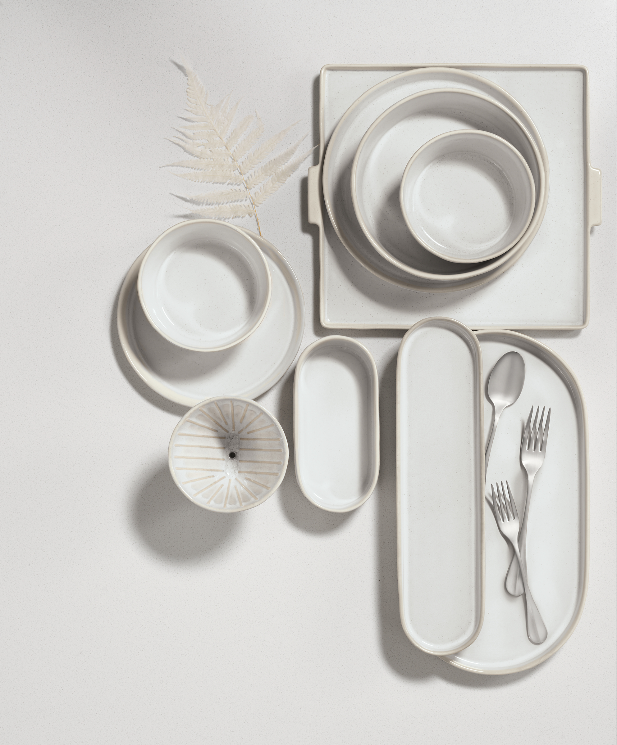 overhead view of notos dishware in white stacked on tabletop.