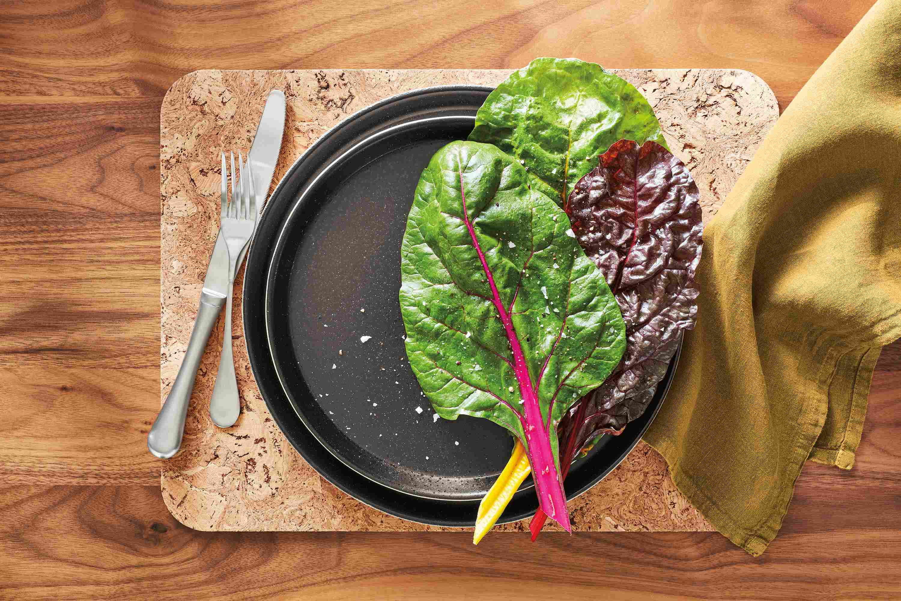 detail of notos plates in black, antigo fork and knife, maria napkin and owen placemat.