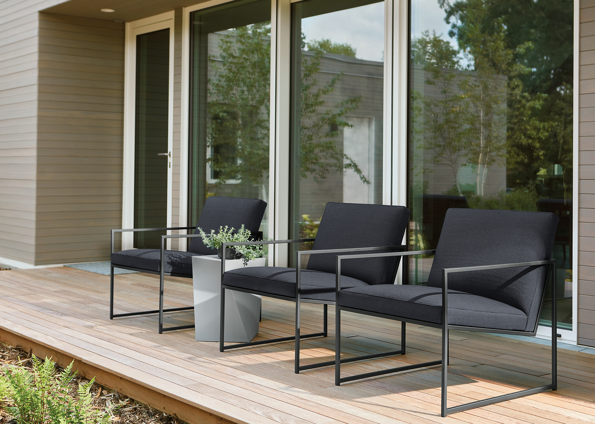 Outdoor space with 3 Nouvel chairs in Niro Charcoal fabric.