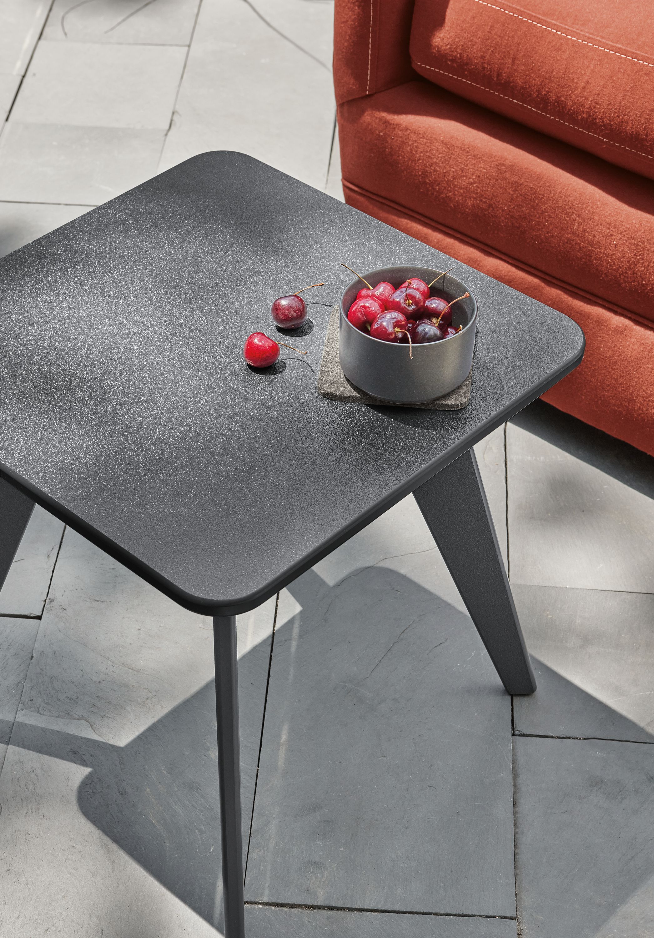 Outdoor patio setting with Nova side table in Grey and Sunford Swivel Chair.