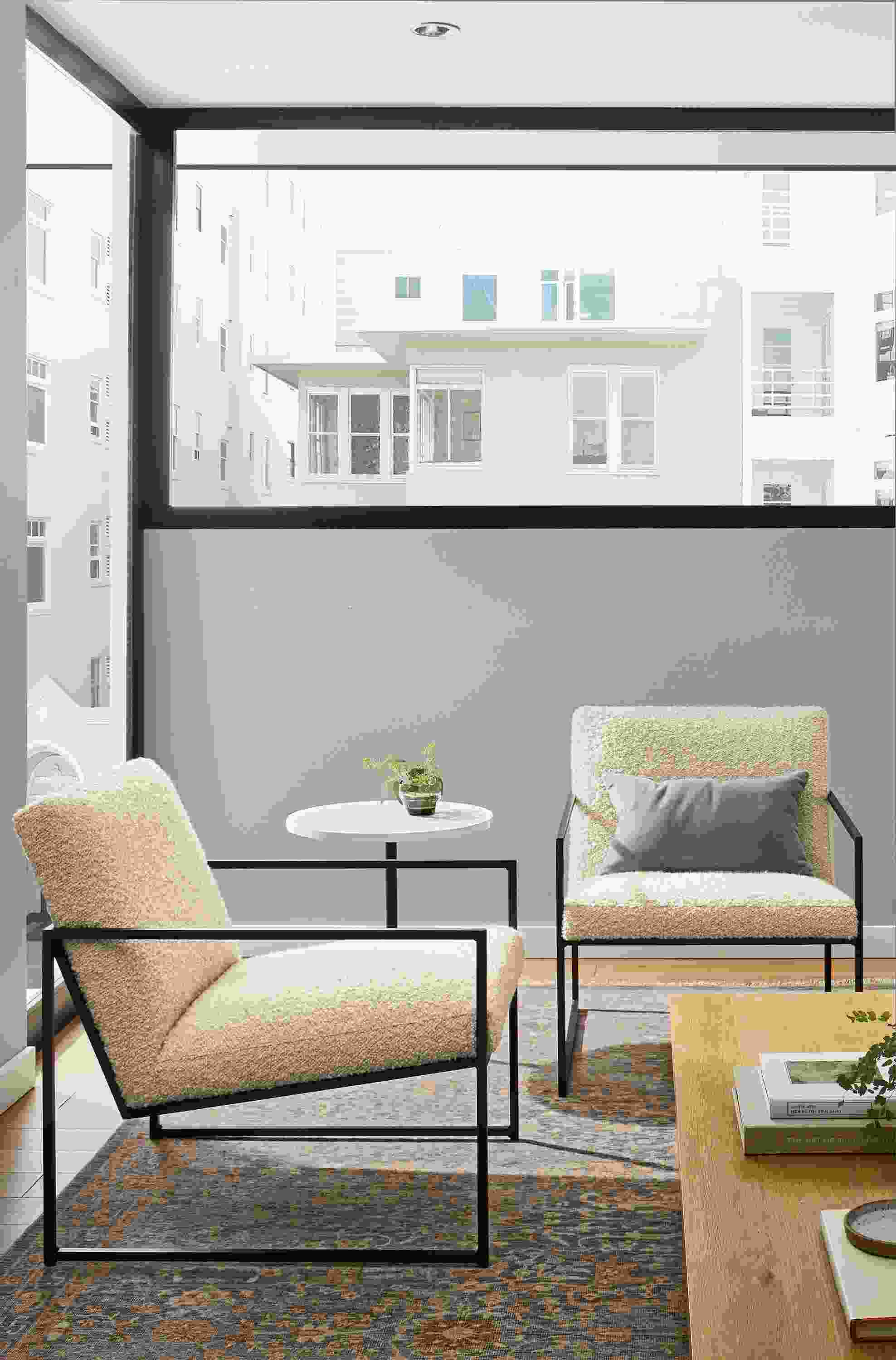 Living room with 2 Novato chairs in Dornick Ivory, Aria round table in graphite with white quartz top.