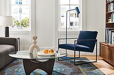 Living area with Novato chair in view indigo fabric, Sanders coffee table in charcoal and glass and Heriz rug in ink.