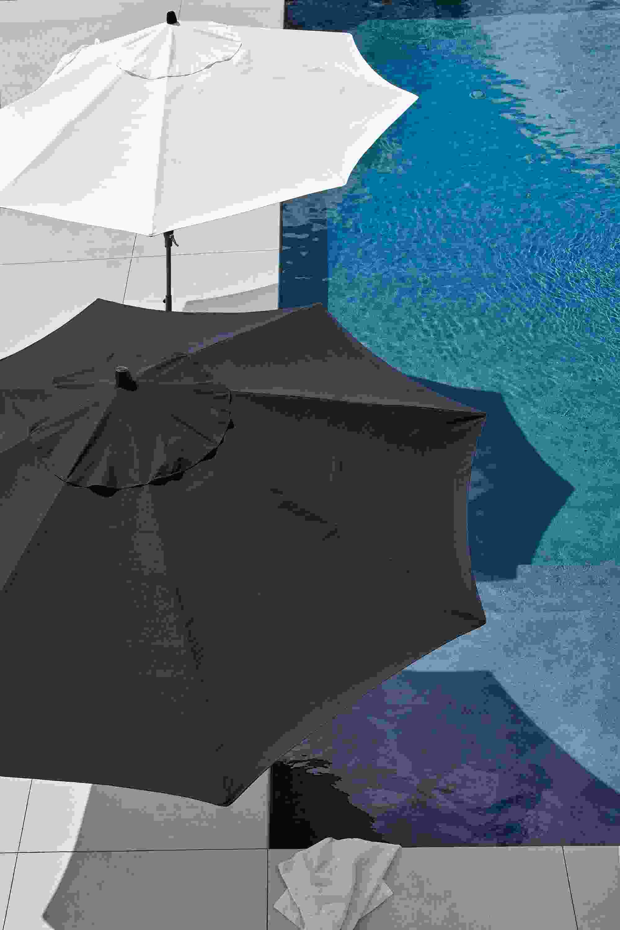 Overhead view of pool area with oahu patio umbrellas in tavros white and tavros navy.