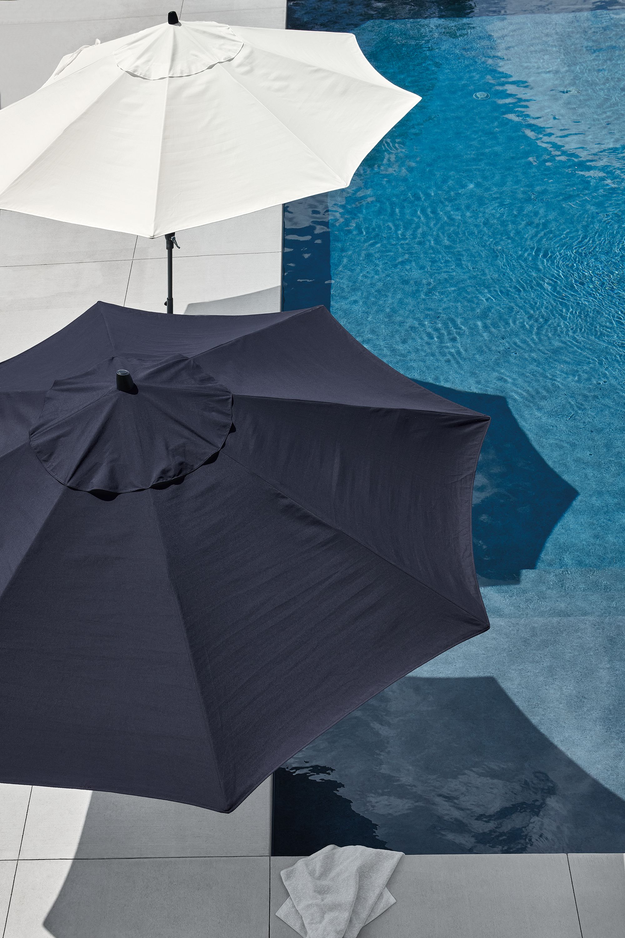 Overhead view of pool area with oahu patio umbrellas in tavros white and tavros navy.