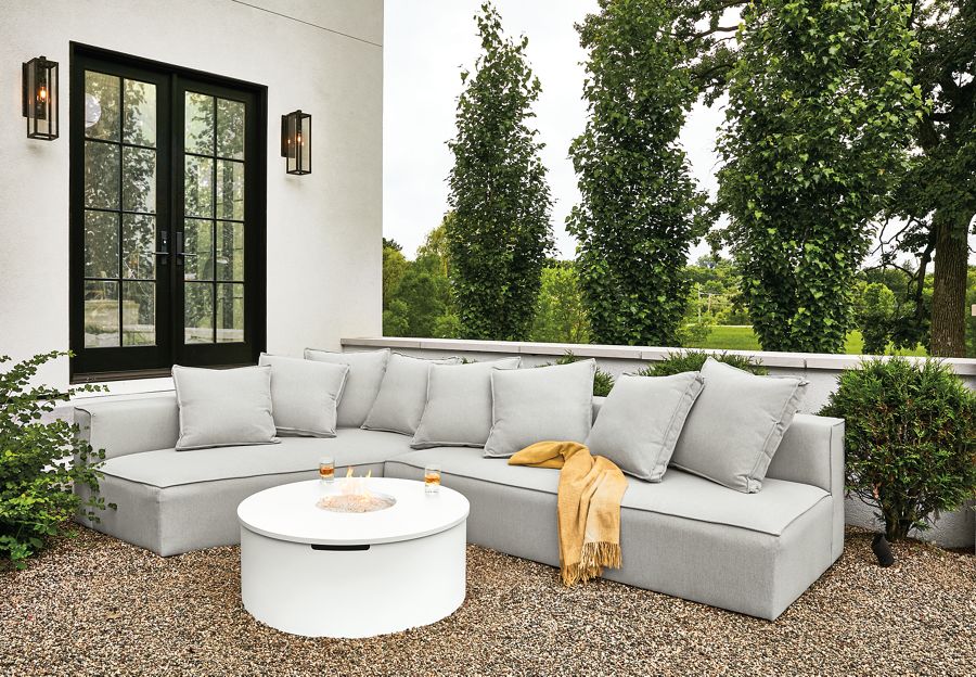 Detail of Oasis outdoor sofa in Mist grey fabric and Adara round fire table in white.
