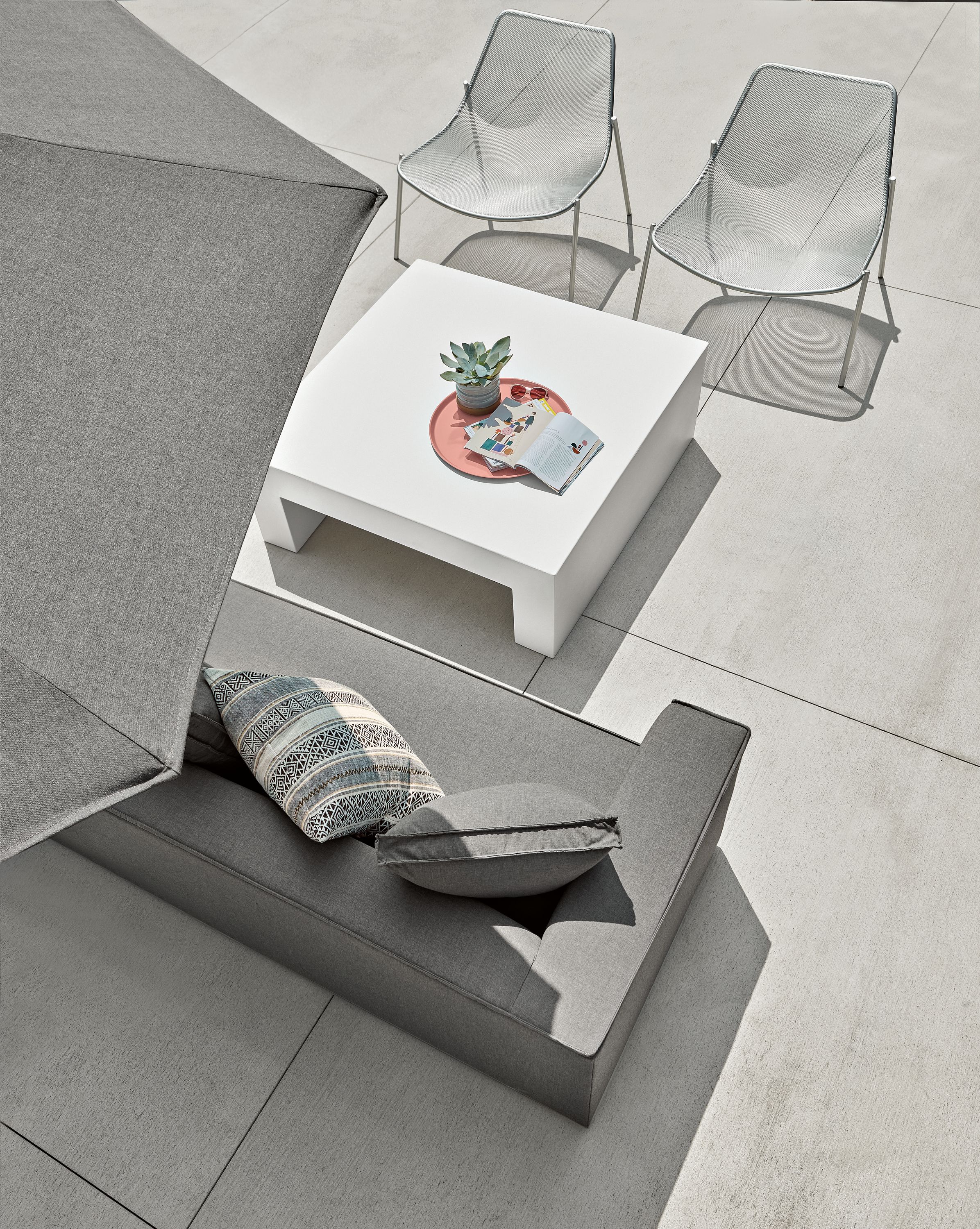 Outdoor patio setting with Oasis sofa and Vignelli coffee table and Solieil lounge chair.
