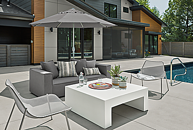 Outdoor patio setting with Oasis sofa and Vignelli coffee table and Solieil lounge chair.