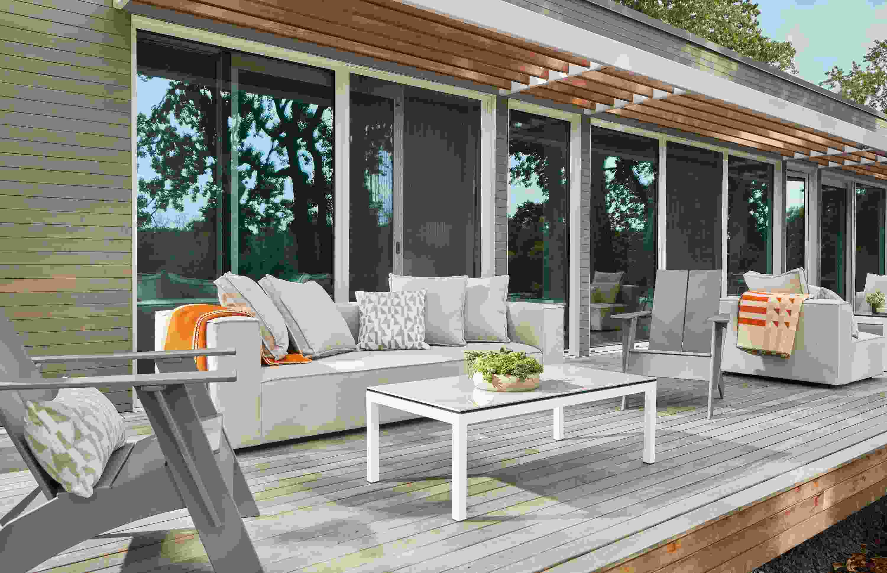 Outdoor space with Oasis sofa and chairs in Niro Beige, Emmet chairs in putty and Parsons coffee table in white.