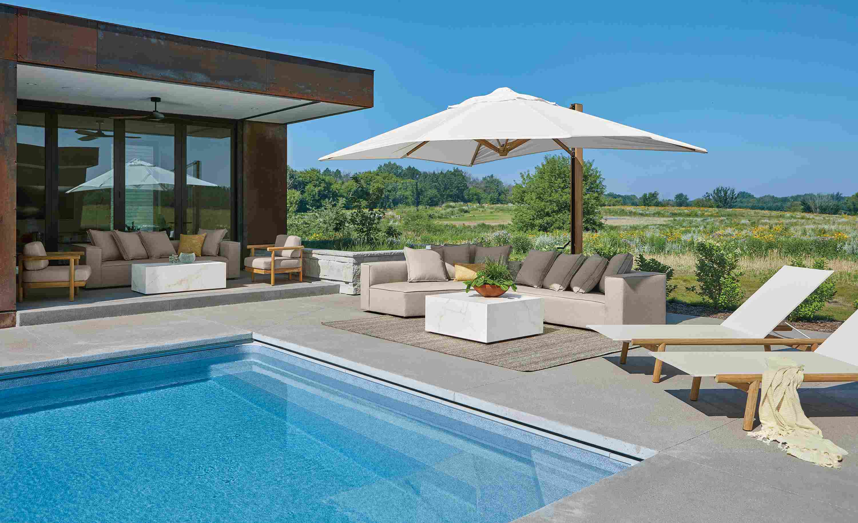 Pool with Oasis right arm sofa in Mist Oatmeal and 2 Isley chaises in teak heartwood with salt outdoor sling.