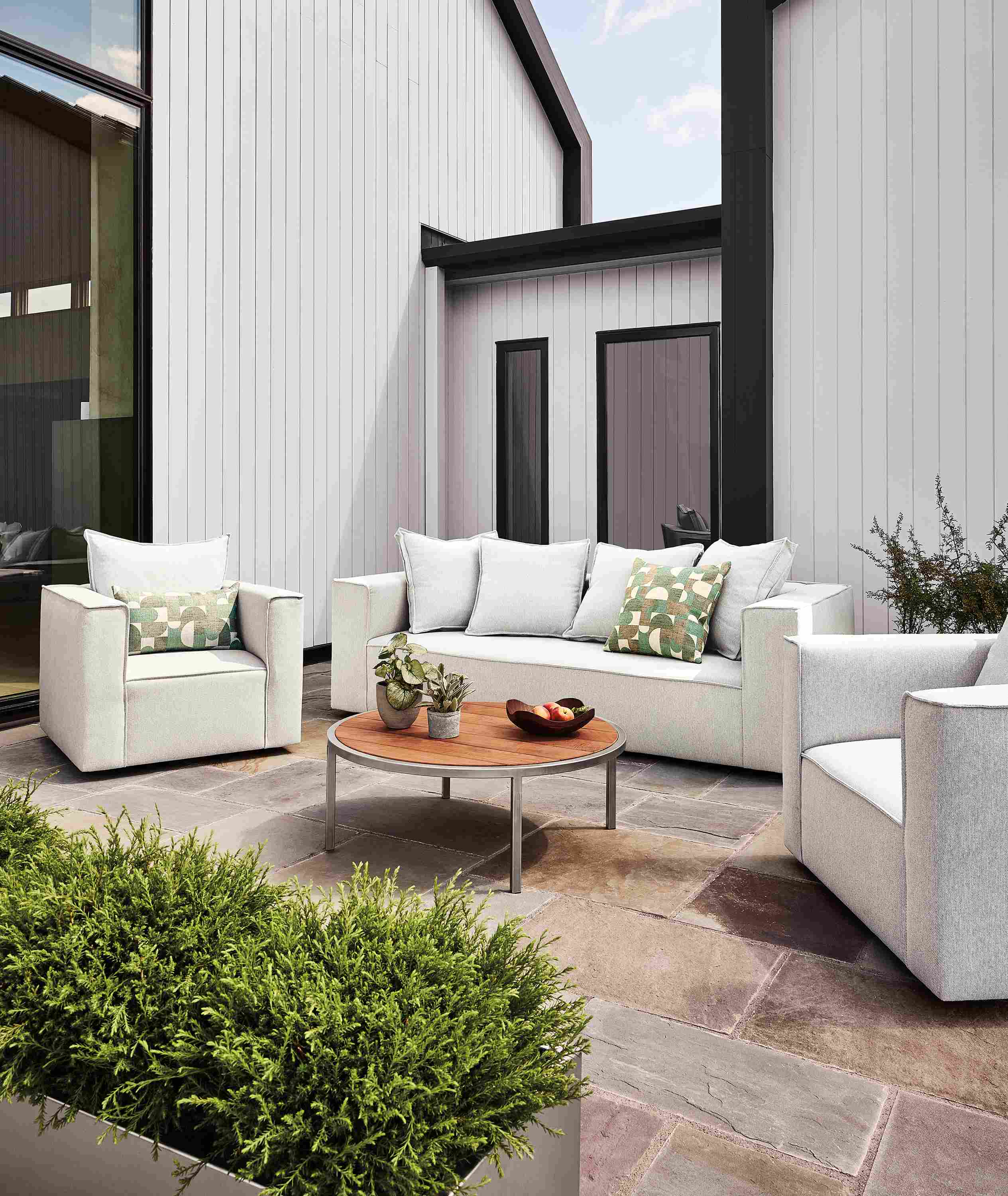 Patio with oasis sofa,  2 swivel chairs, 2 square ottomans in mist grey and a montego coffee table in stainless.