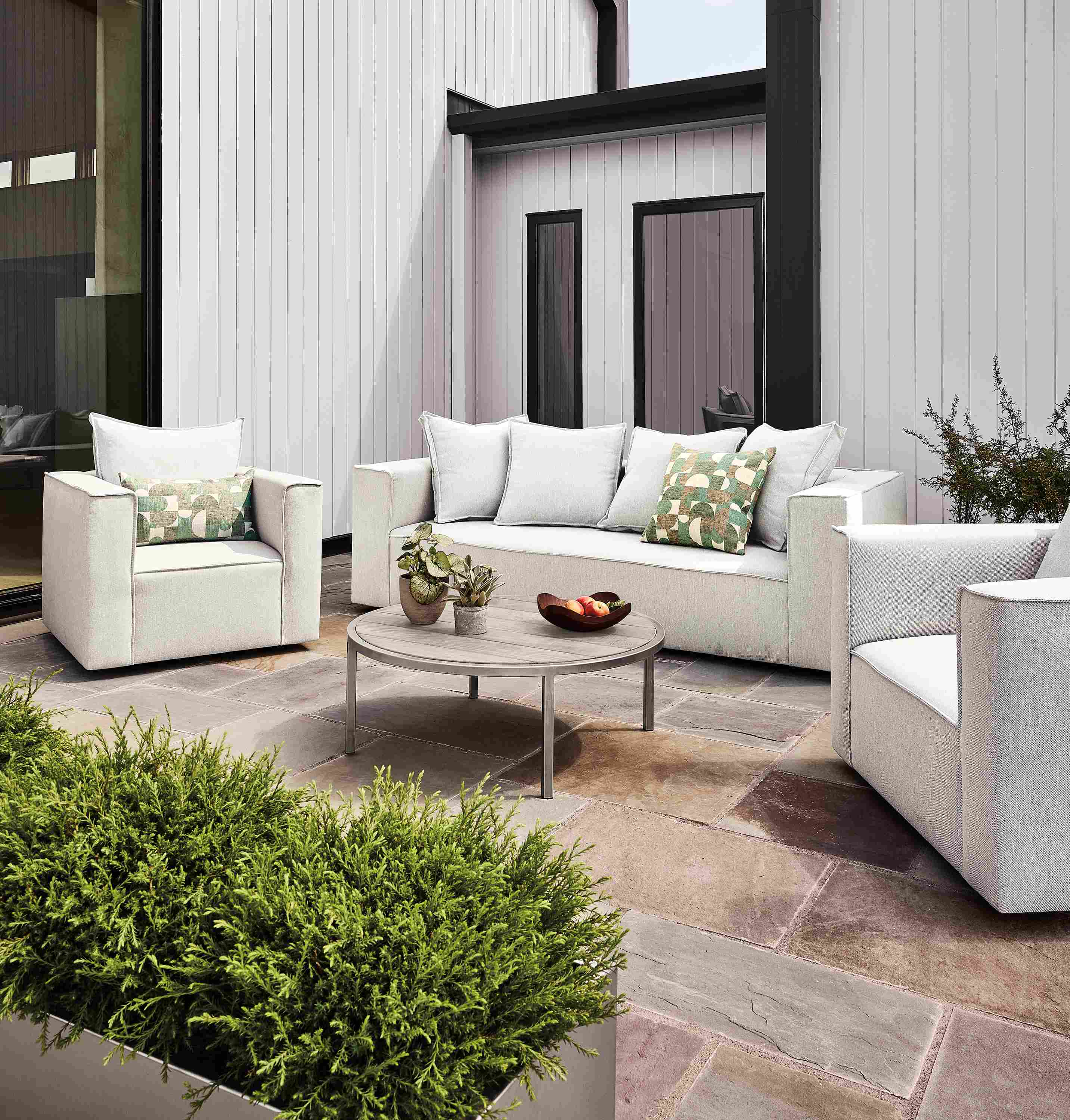 Patio with oasis sofa,  2 swivel chairs, 2 square ottomans in mist grey and a montego aged ash coffee table.