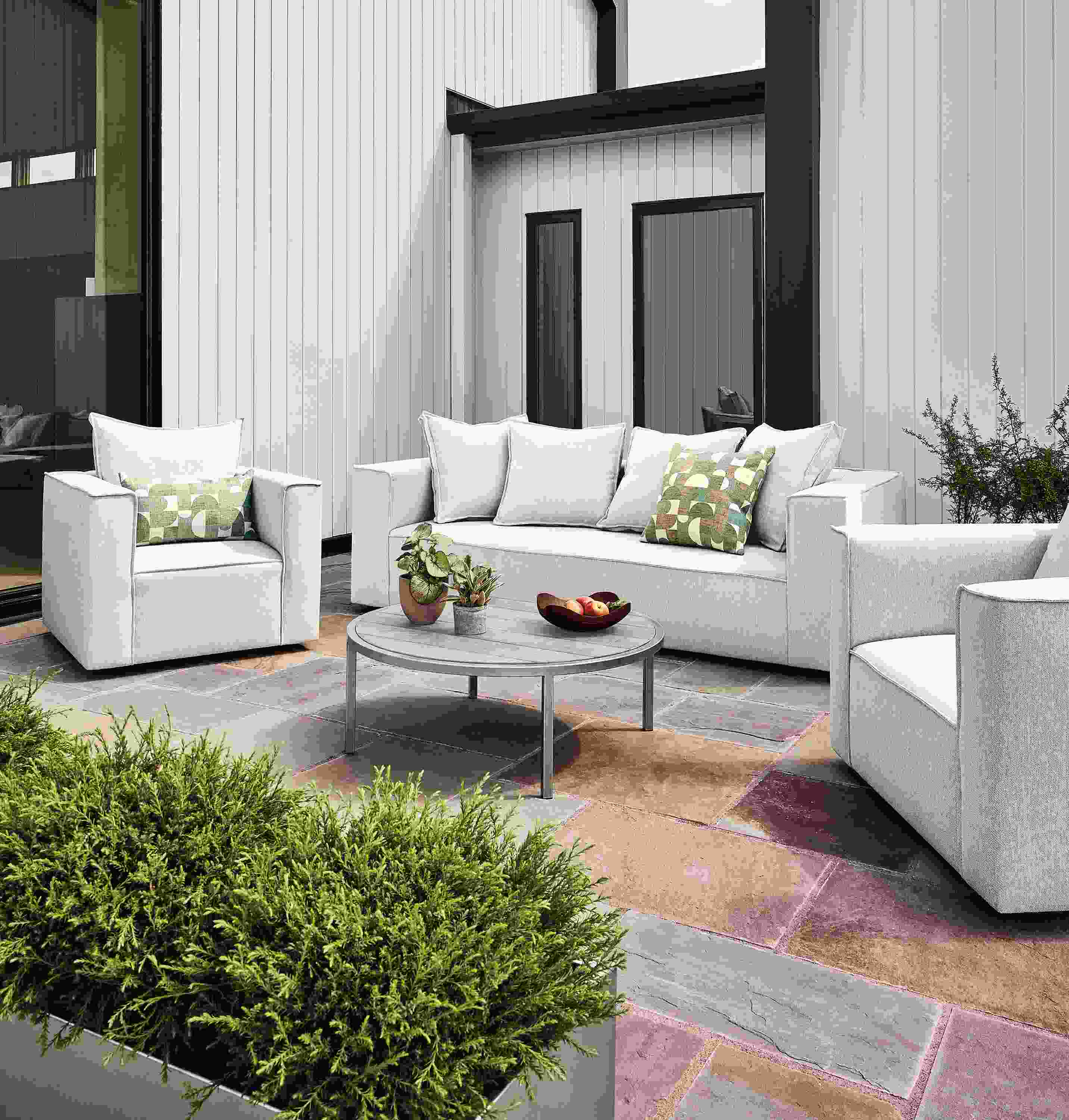 Patio with oasis sofa,  2 swivel chairs, 2 square ottomans in mist grey and a montego aged ash coffee table.