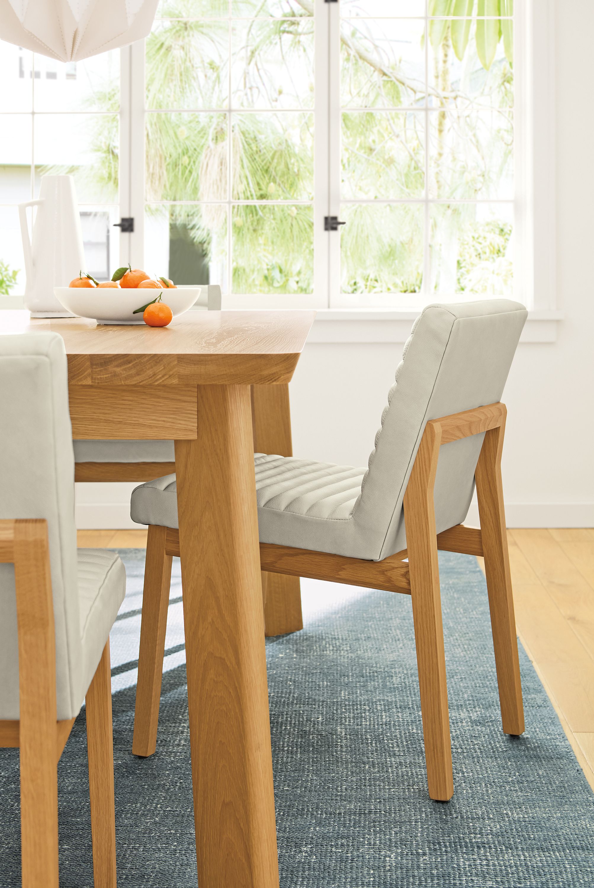 Dining room with 3 Olsen side chairs in Laino Bone leather and Colby 72-wide table in white oak.