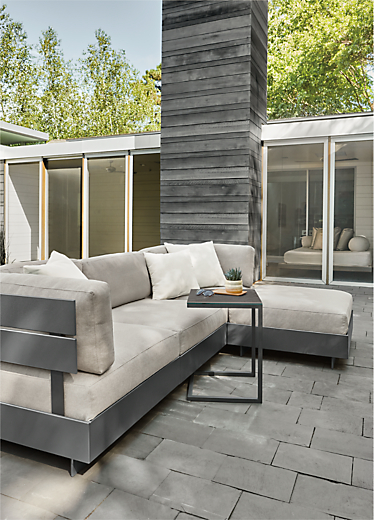 Outdoor patio setting with an Omni modular sofa and Pratt outdoor c-shaped side table.  