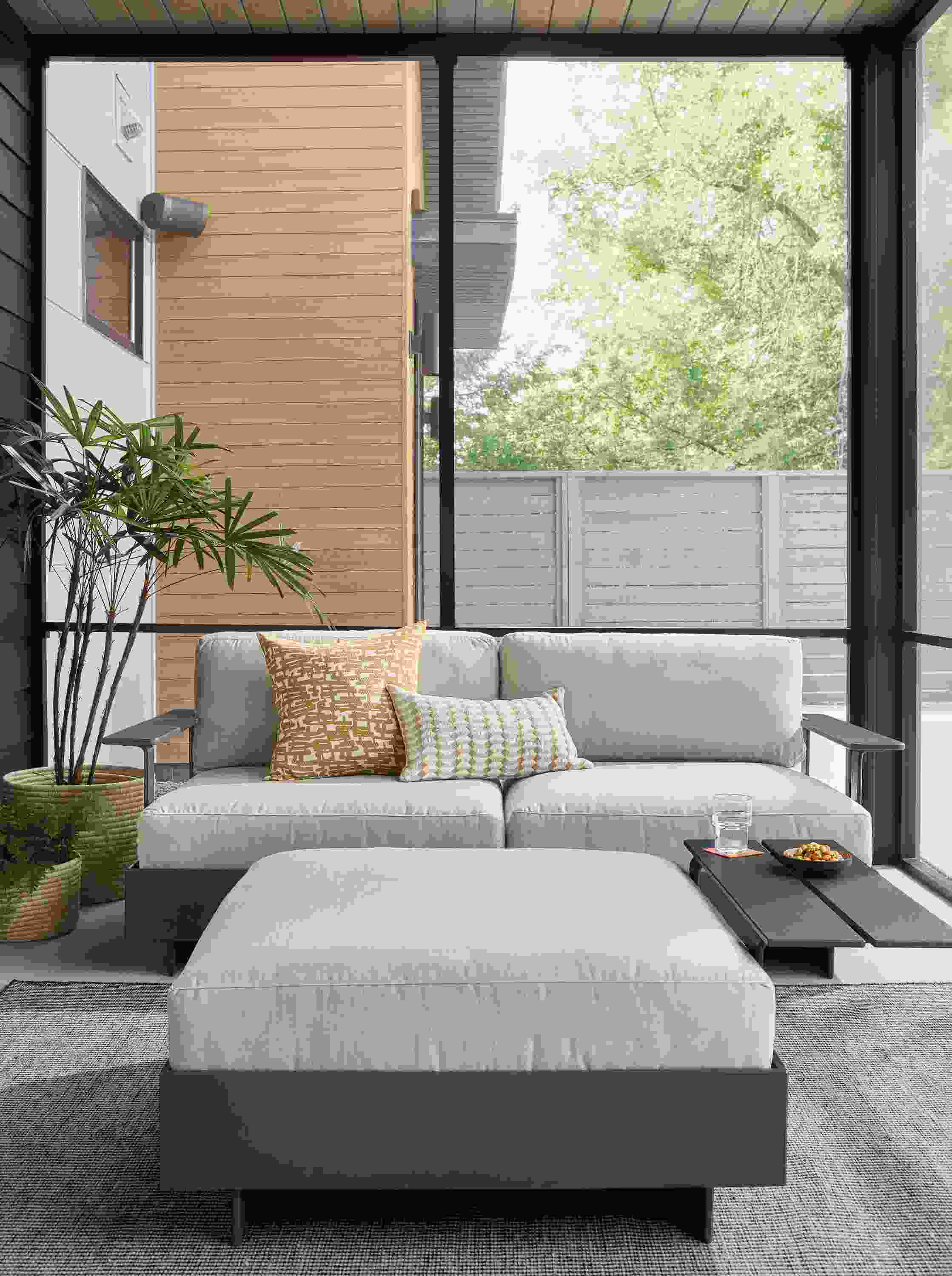 Room setting with Omni Two-Piece Sofa and Ottoman with a Selby Rug in Black.