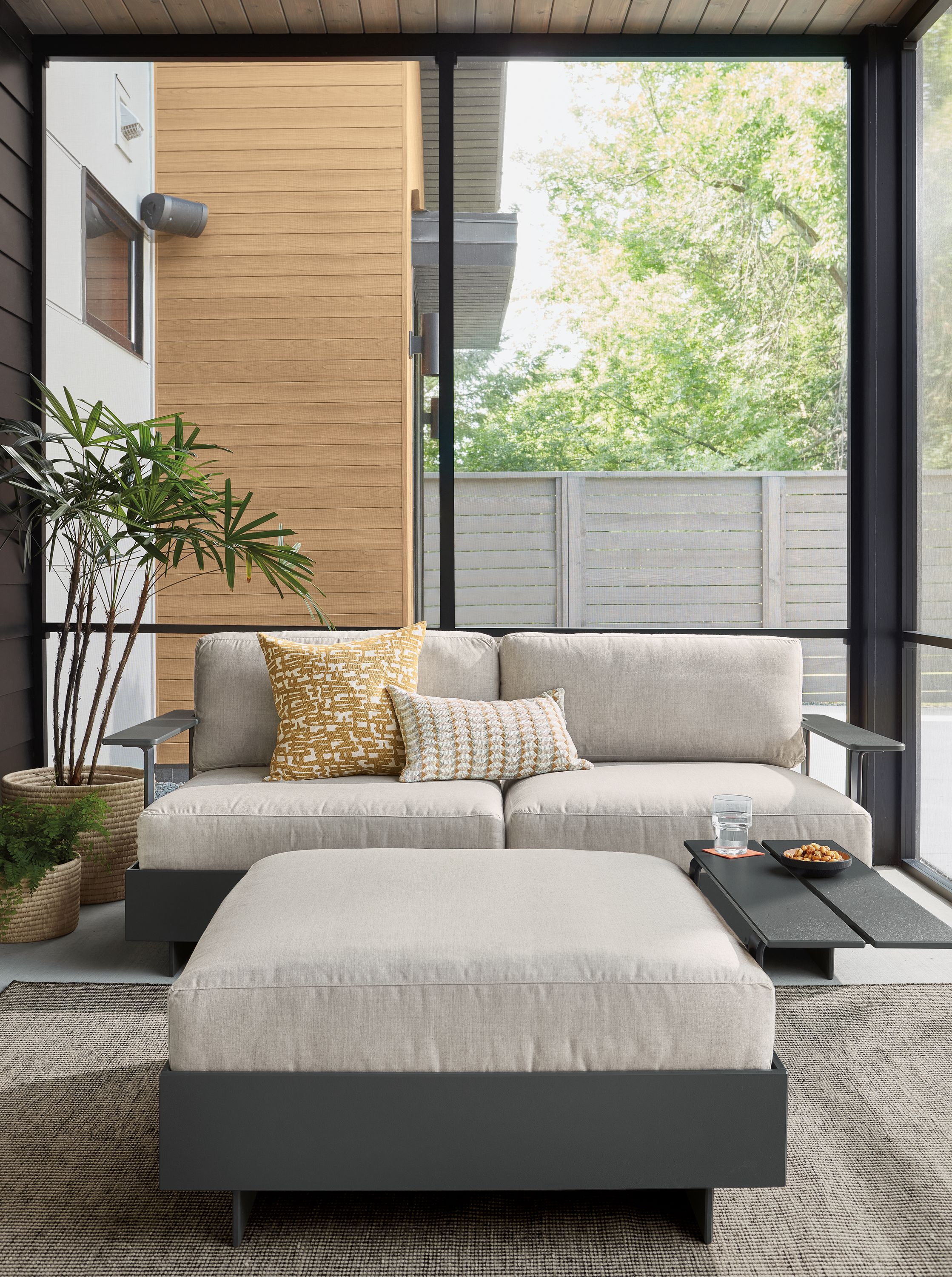 Room setting with Omni Two-Piece Sofa and Ottoman with a Selby Rug in Black.