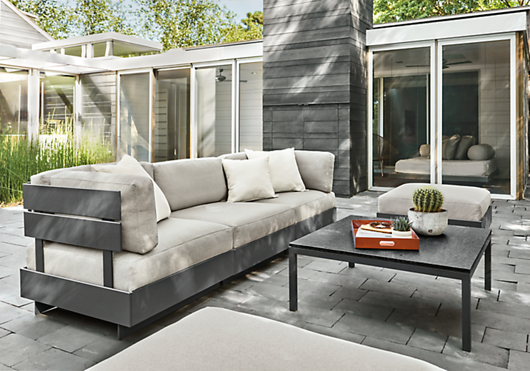 Outdoor patio setting with Omni Three-Piece Modular Sofa and Ottoman with a Pratt Outdoor Coffee Table.